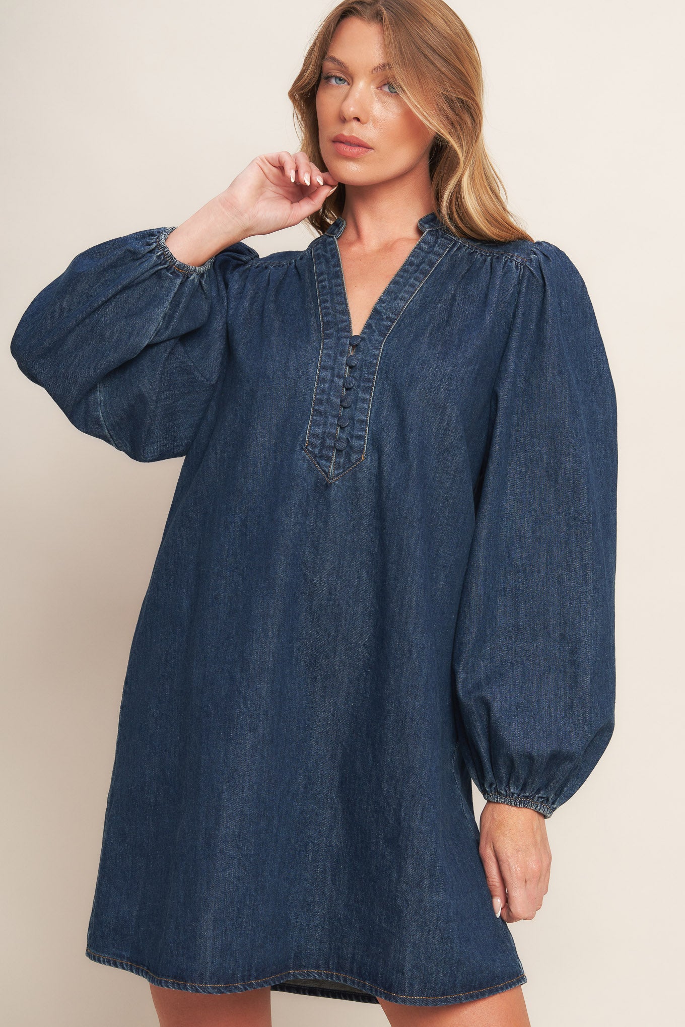 A washed denim mini dress featuring round neckline with V front, button down and long sleeve