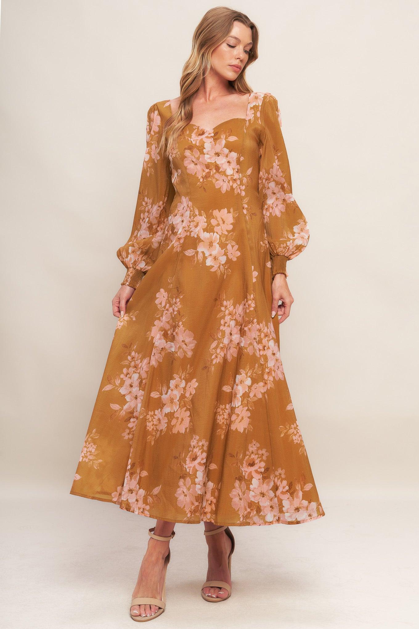 A printed woven ankle dress featuring sweetheart neckline, long sleeve with smocked cuff, circle skirt and back zipper closure