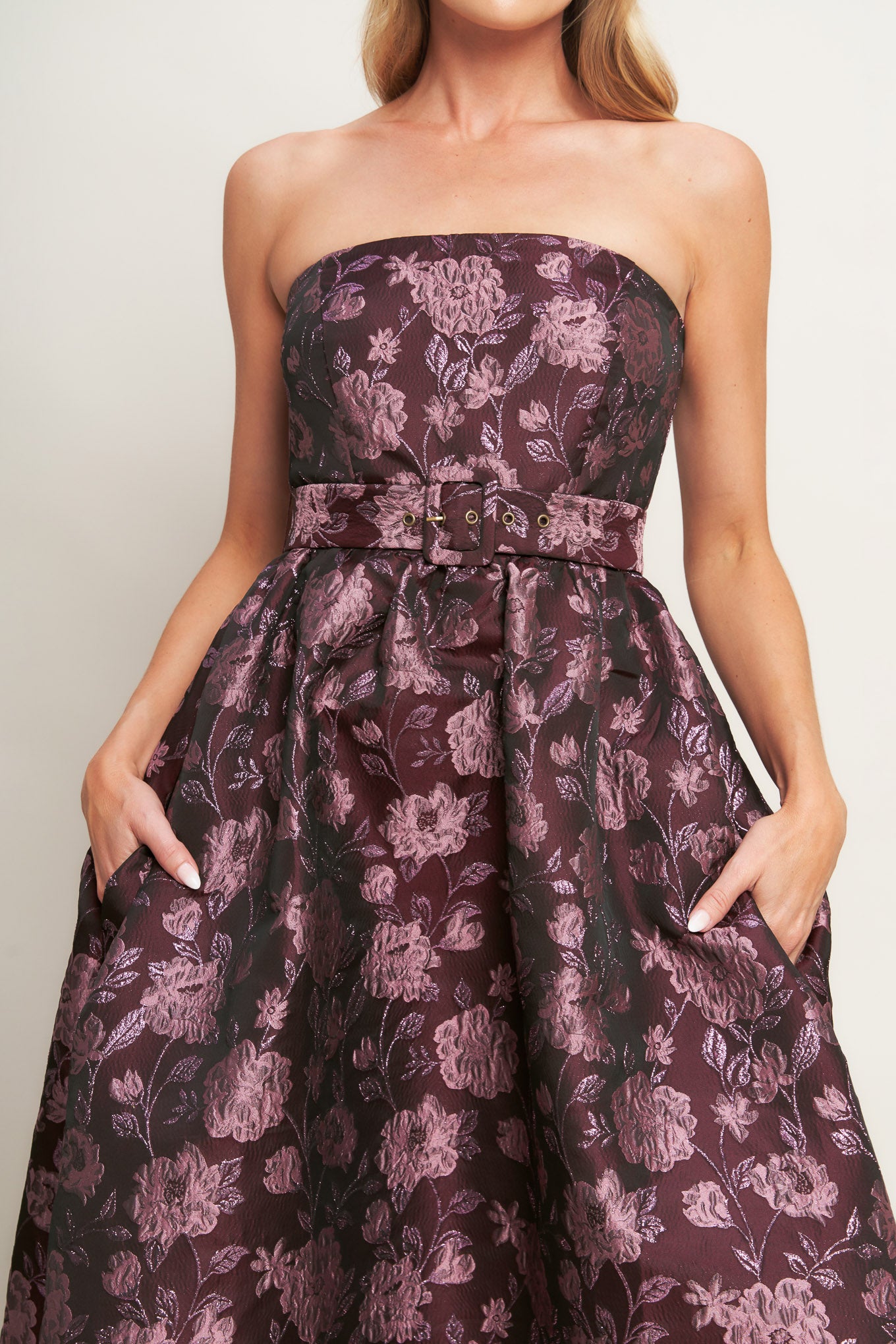 A jacquard woven midi dress featuring strapless neckline, self belt, full skirt and back zipper closure