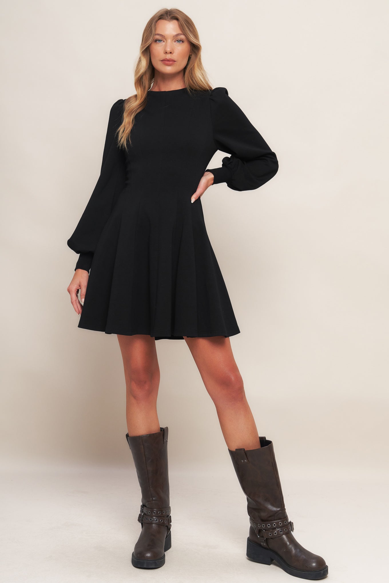 A solid heavy knit mini dress featuring round neckline, long sleeve with cuff, circle skirt and back zipper closure