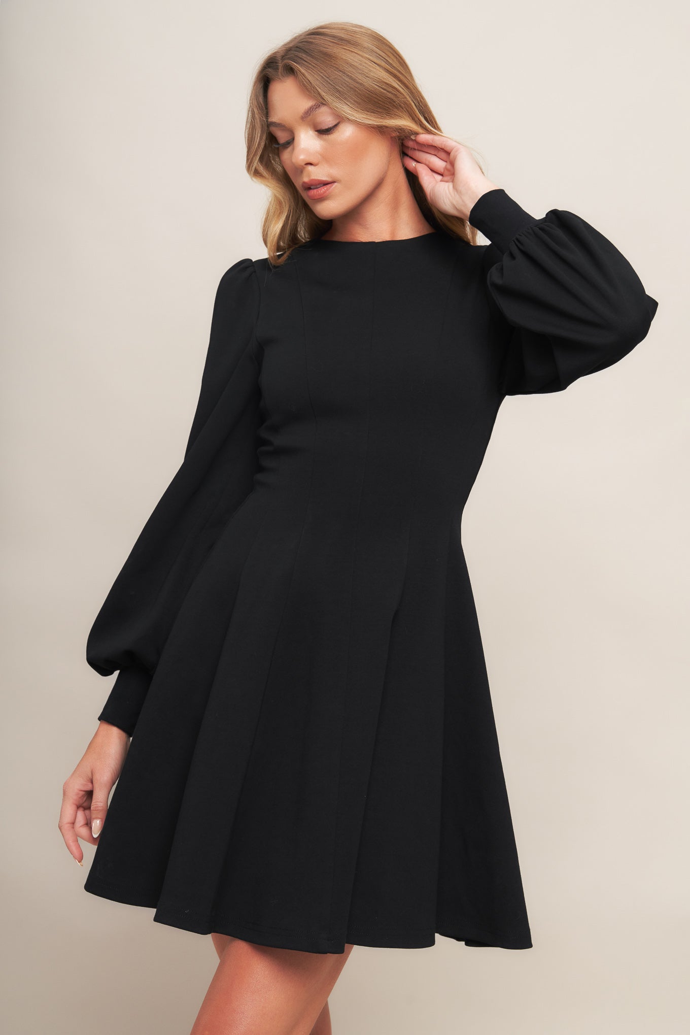 A solid heavy knit mini dress featuring round neckline, long sleeve with cuff, circle skirt and back zipper closure