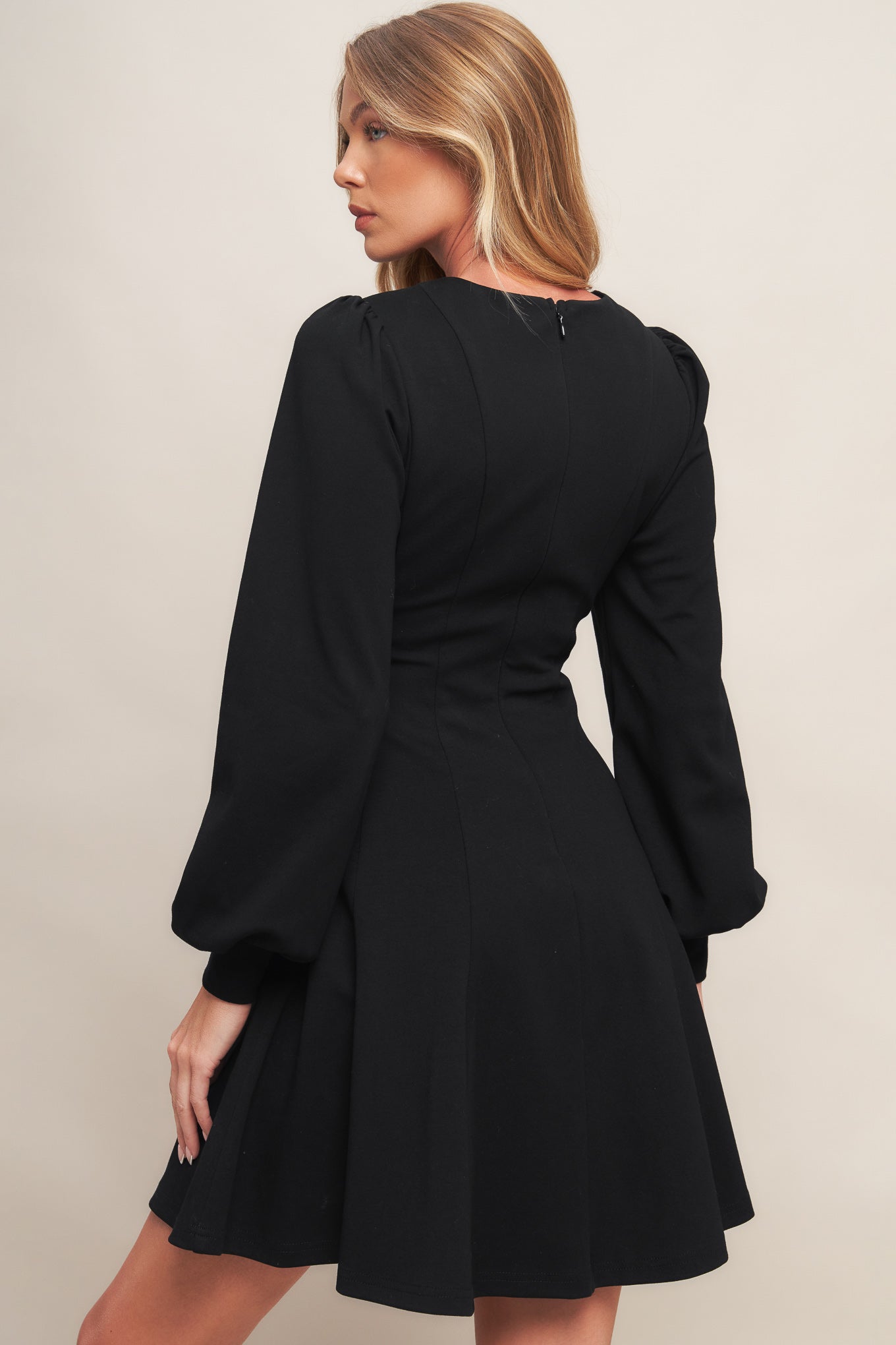 A solid heavy knit mini dress featuring round neckline, long sleeve with cuff, circle skirt and back zipper closure