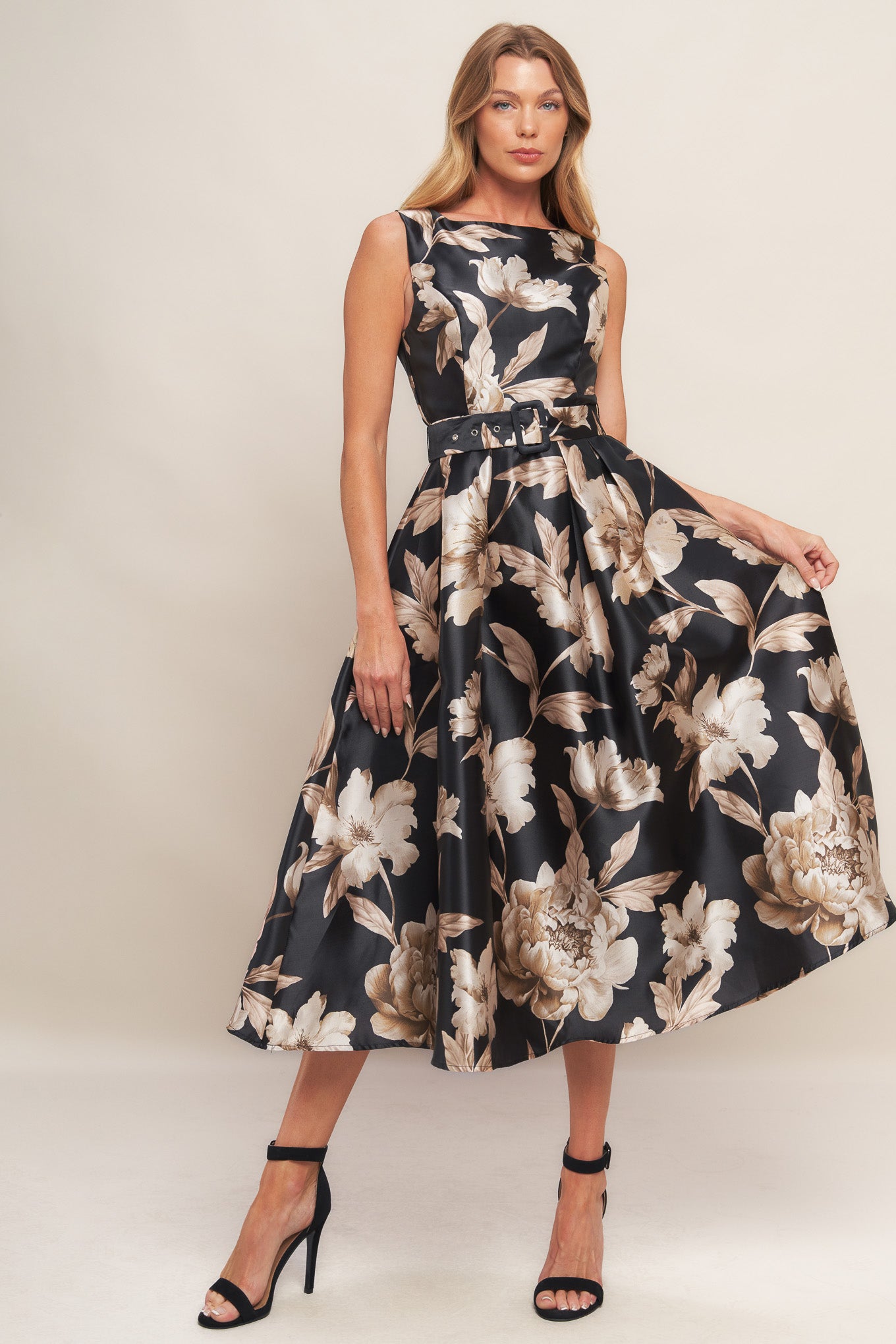 A printed woven midi dress featuring wide neckline, sleeveless, self belt, full skirt and back zipper closure