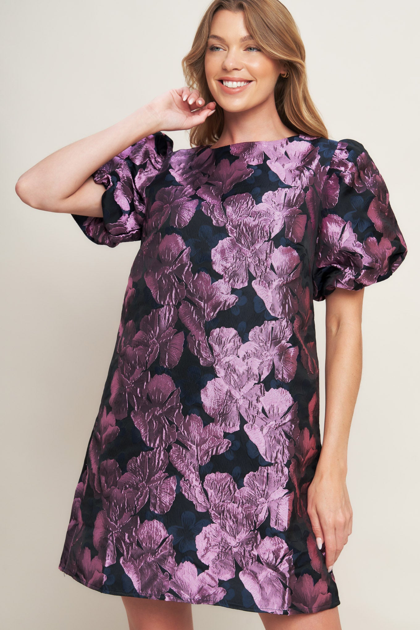 A textured woven mini dress featuring round neckline, short puff sleeve and back neck button closure