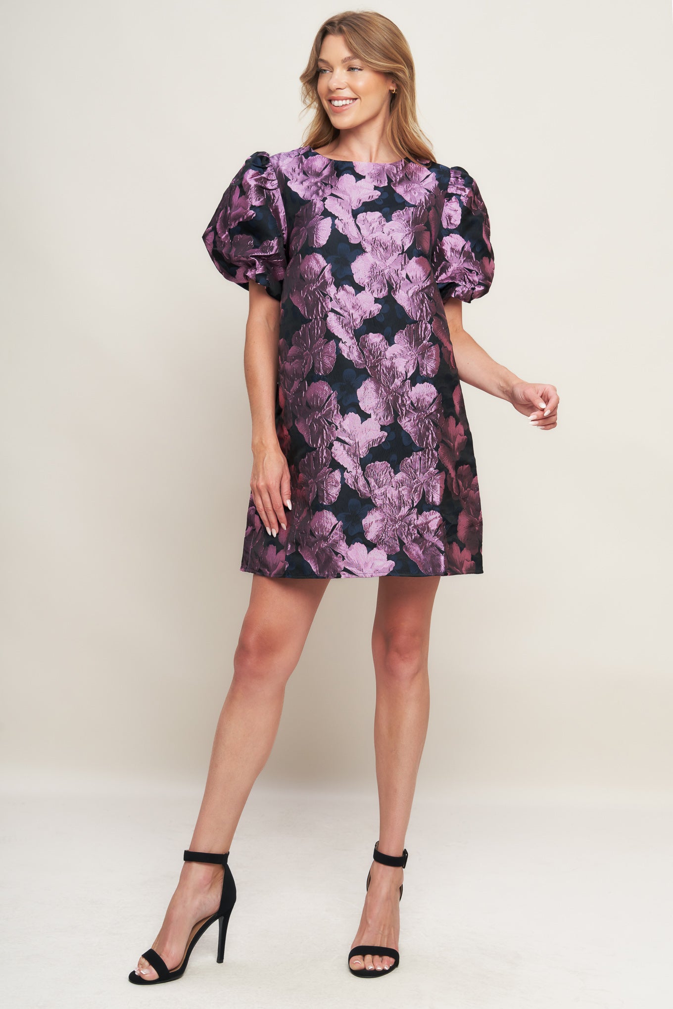 A textured woven mini dress featuring round neckline, short puff sleeve and back neck button closure
