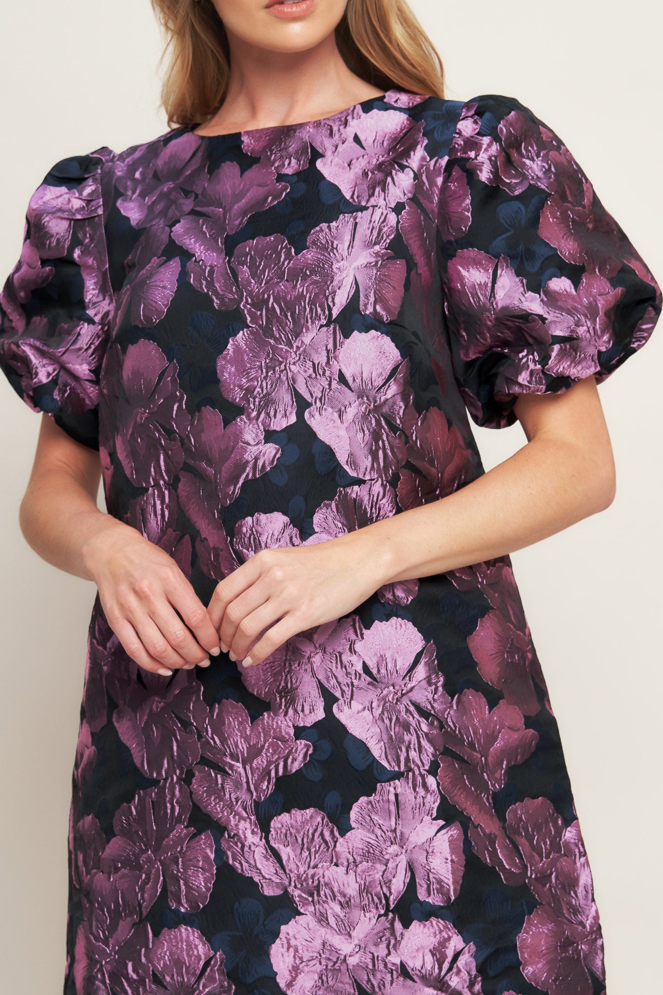 A textured woven mini dress featuring round neckline, short puff sleeve and back neck button closure