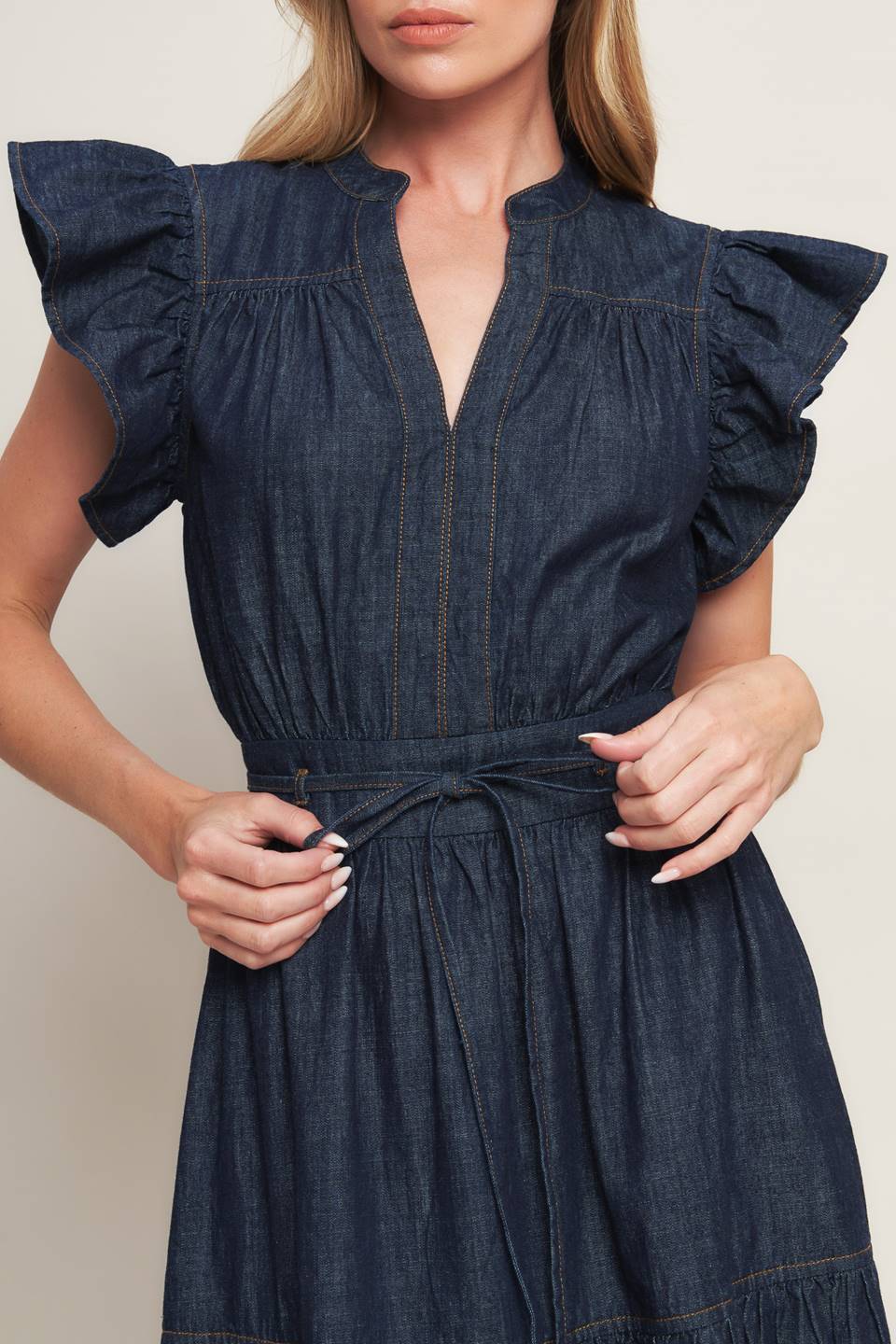 A lightweight denim midi dress featuring V neckline, short ruffle sleeve, skinny self tie, tiered skirt and smocked back waistband