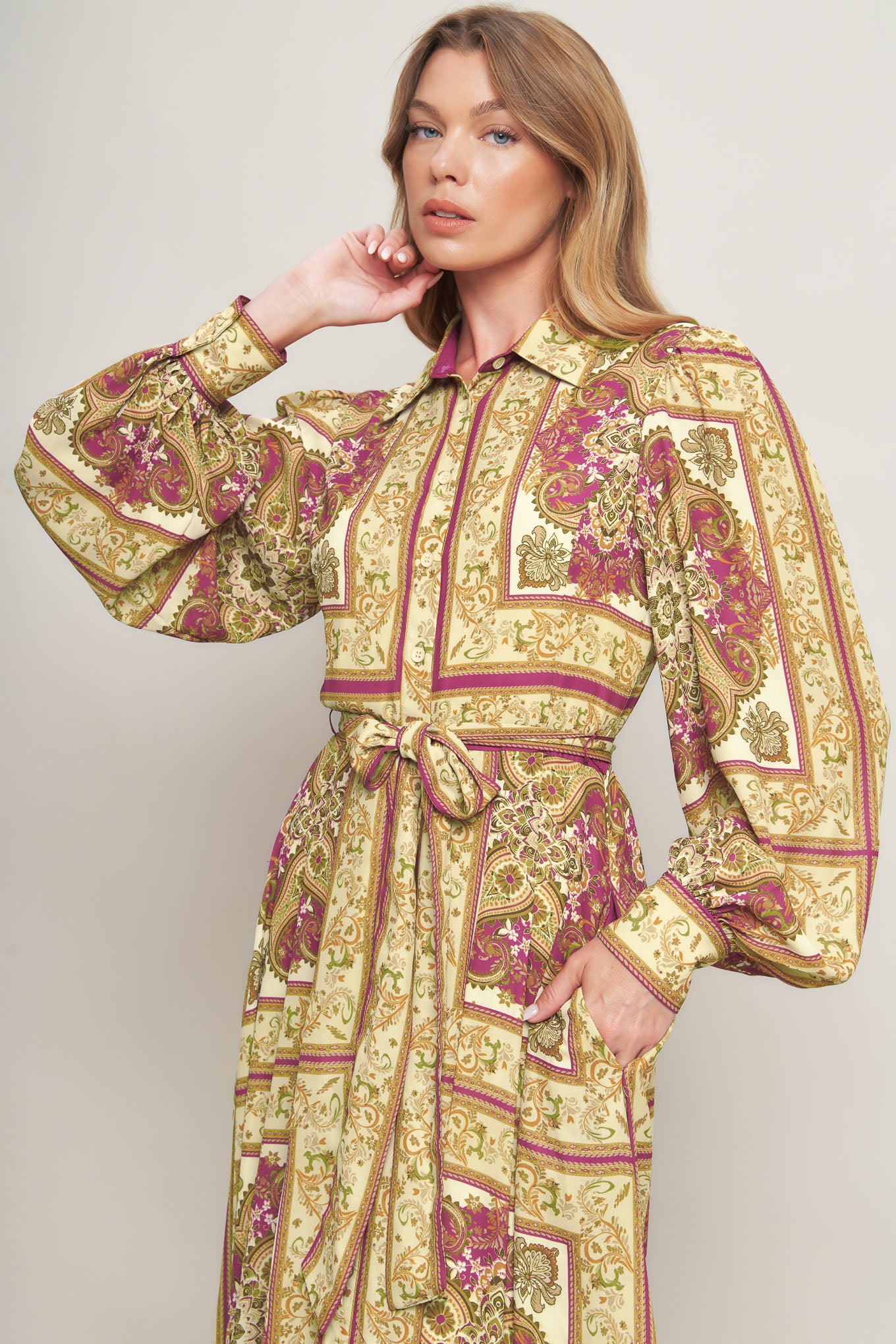 A printed woven maxi dress featuring collar, long sleeve with cuff, front button down, self sash tie and ruffled hemline