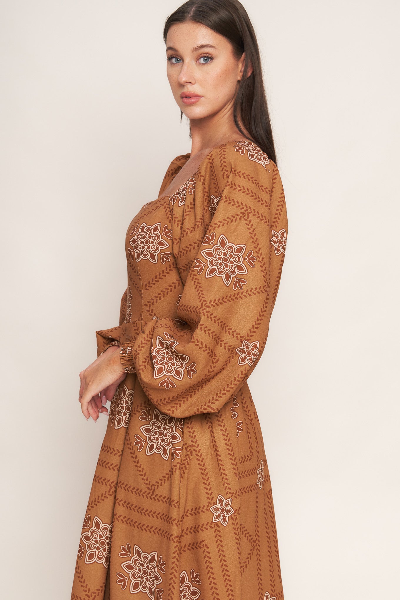 A printed woven midi dress featuring square neckline, long sleeve with smocked cuff, full skirt and smocked back bodice