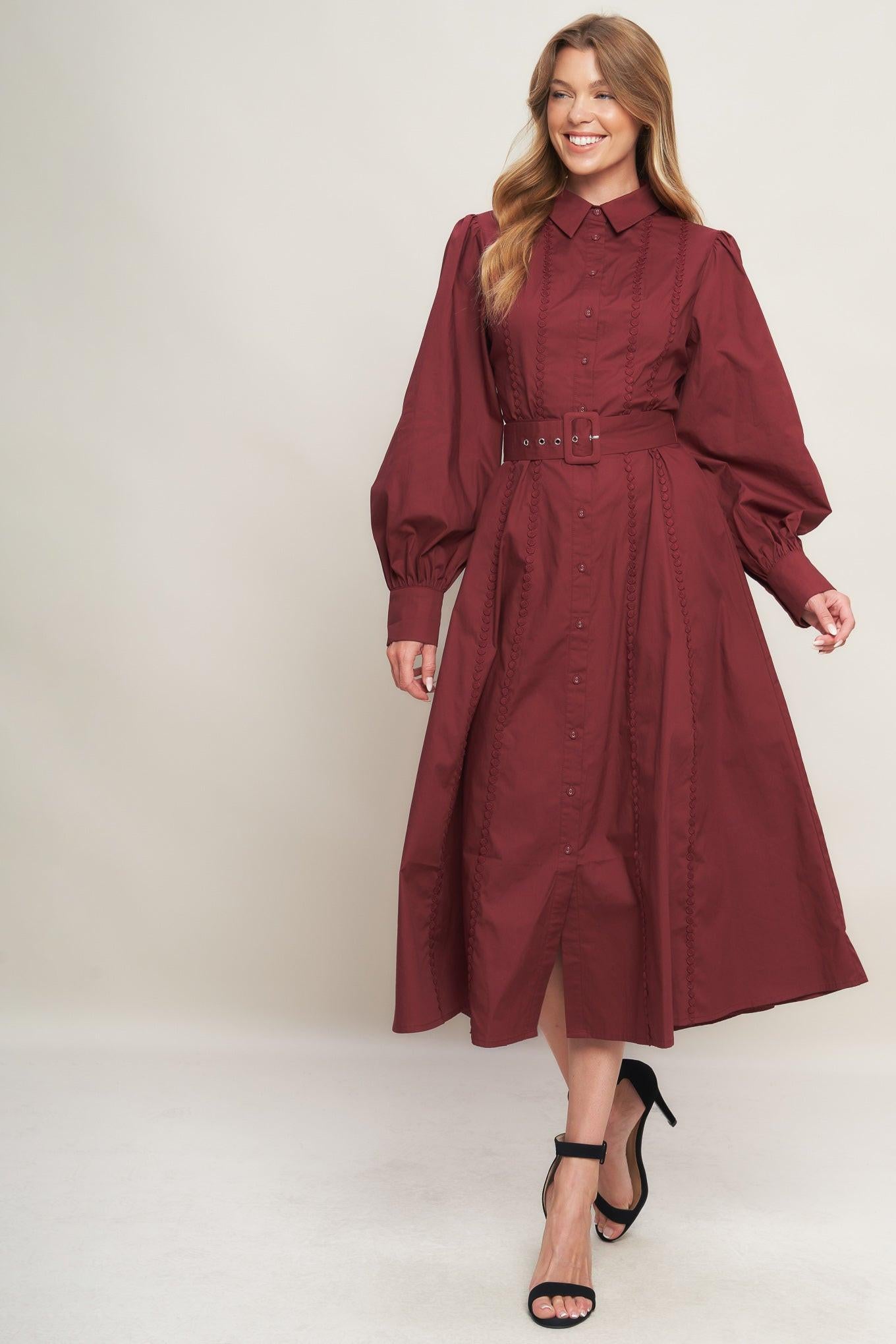 A solid woven midi dress featuring collar, button down, lace trim detail, long sleeve, self belt and full skirt