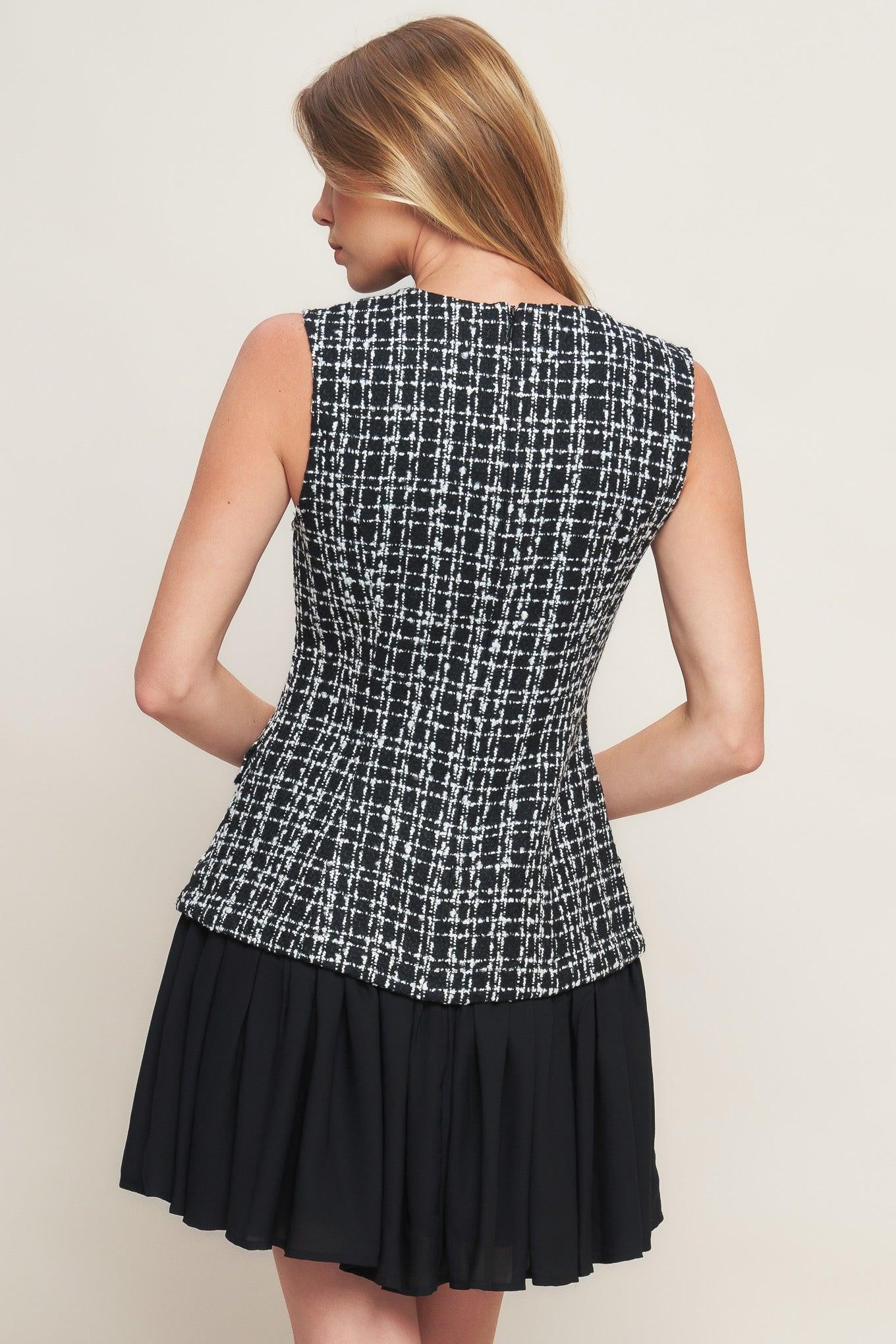 A tweed and solid woven mini dress featuring round neckline, sleeveless, front button down and flowy solid skirt