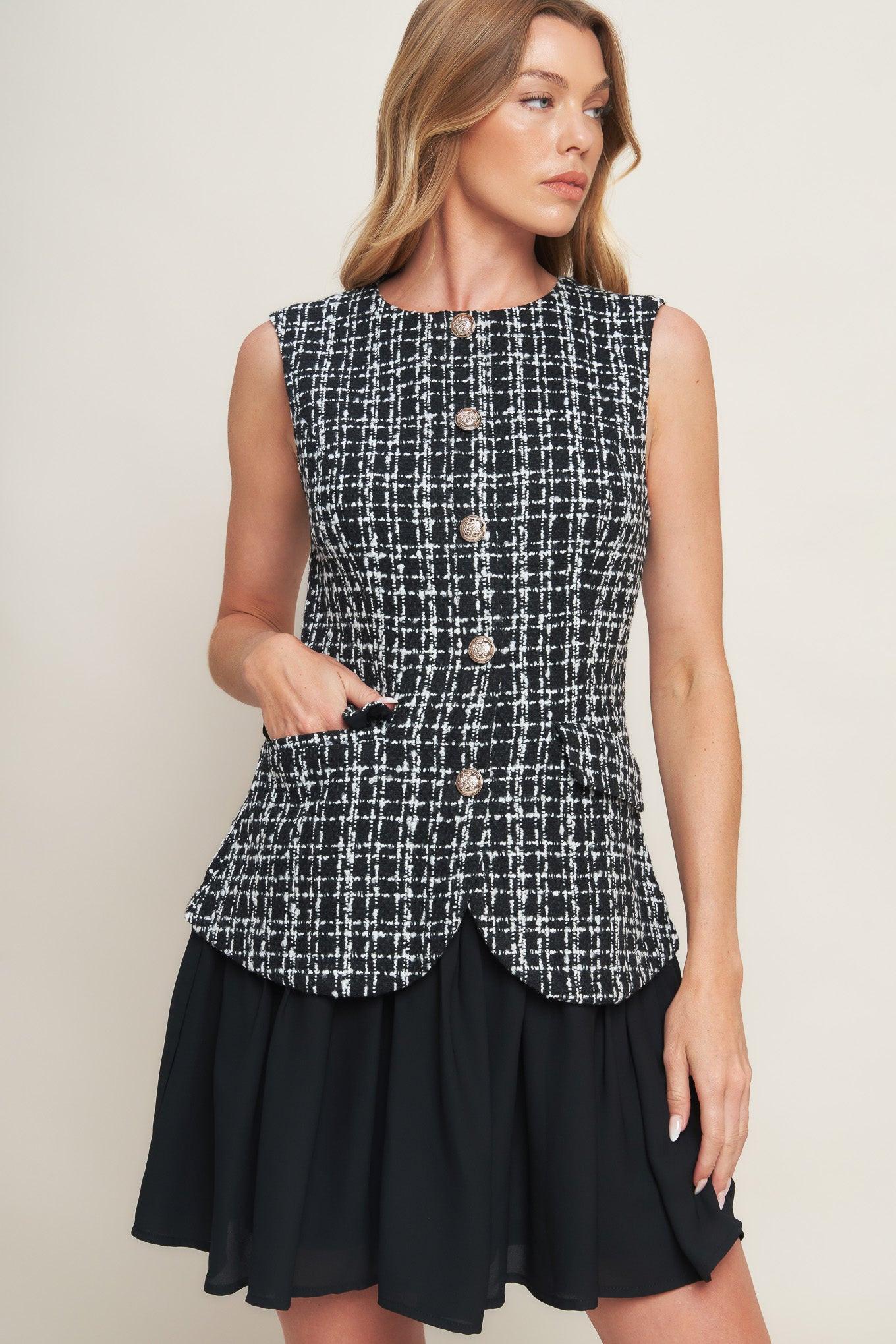 A tweed and solid woven mini dress featuring round neckline, sleeveless, front button down and flowy solid skirt
