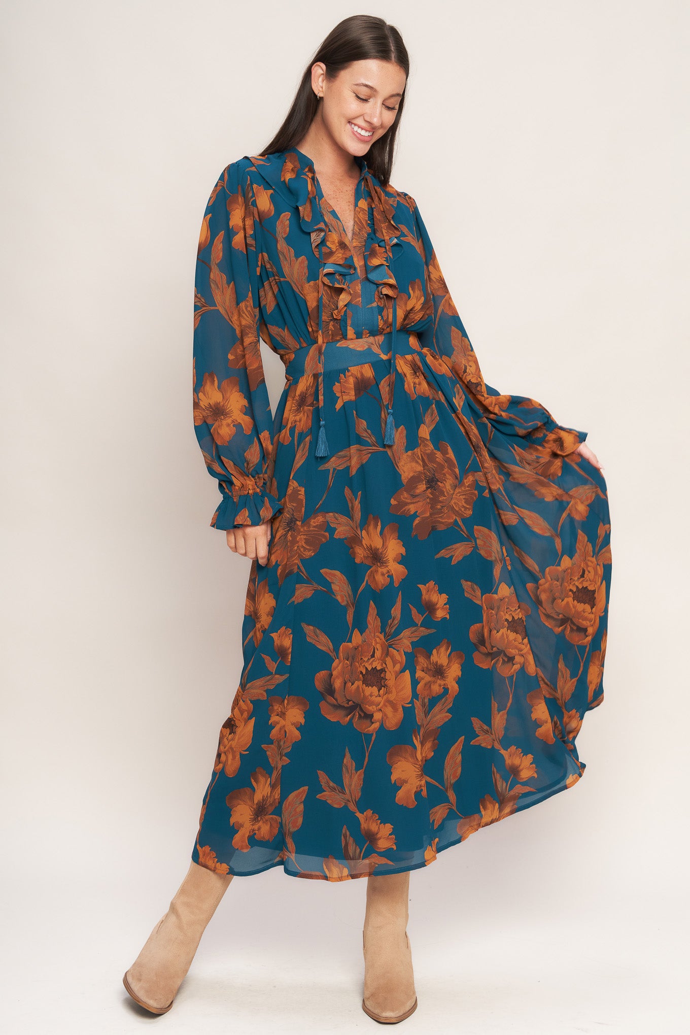 A printed woven midi dress featuring front tie/tassel with ruffles, long sleeve with ruffled cuff and elasticized waist
