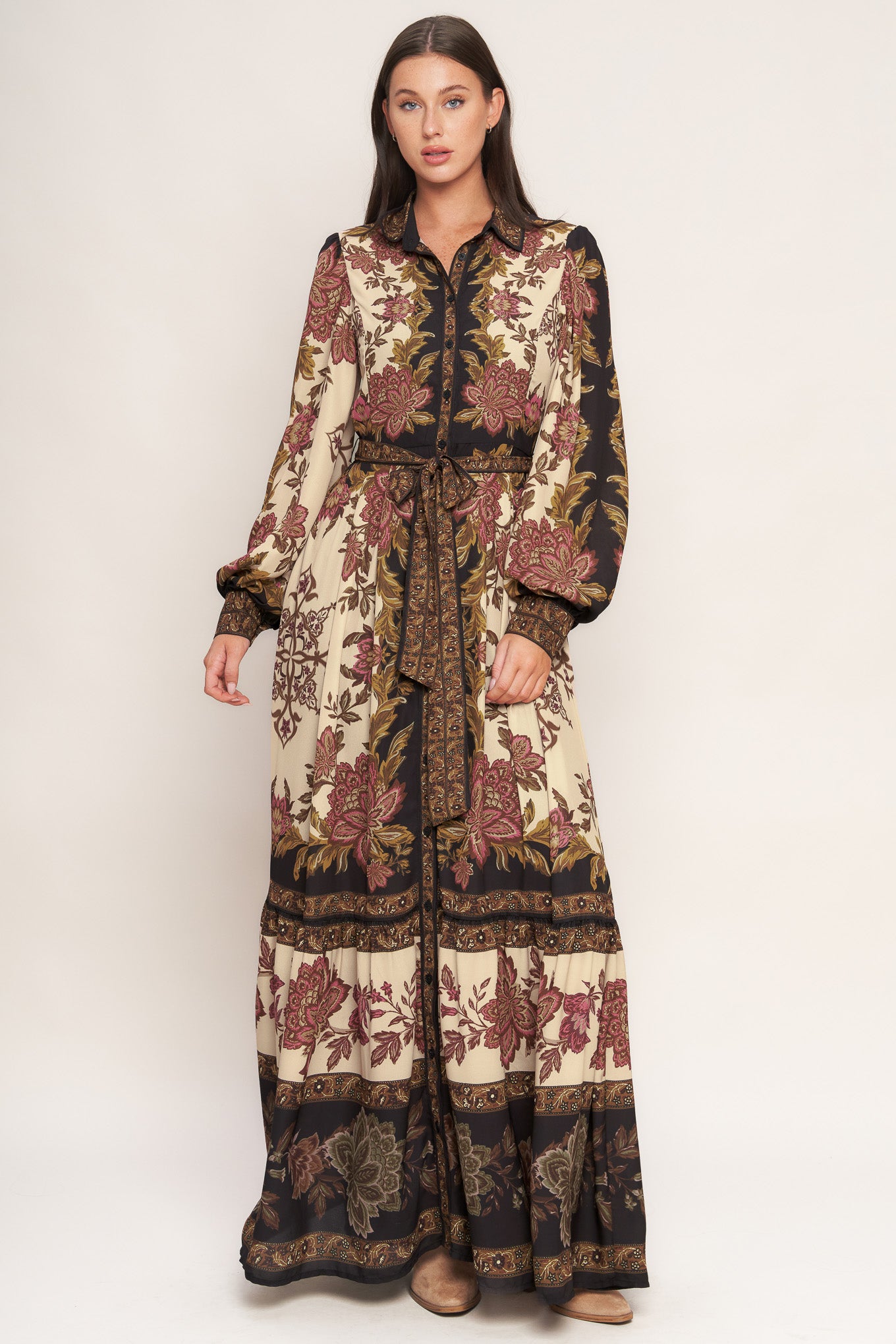 A printed woven maxi dress featuring collar, button down, long sleeve with cuff, self sash tie, and ruffled hemline