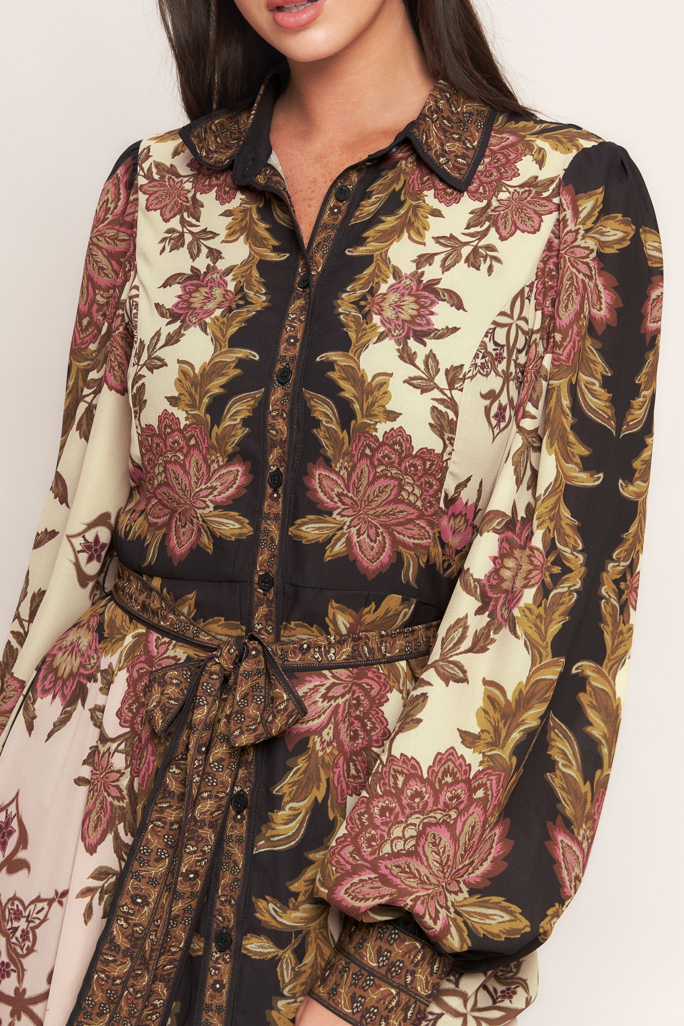 A printed woven maxi dress featuring collar, button down, long sleeve with cuff, self sash tie, and ruffled hemline