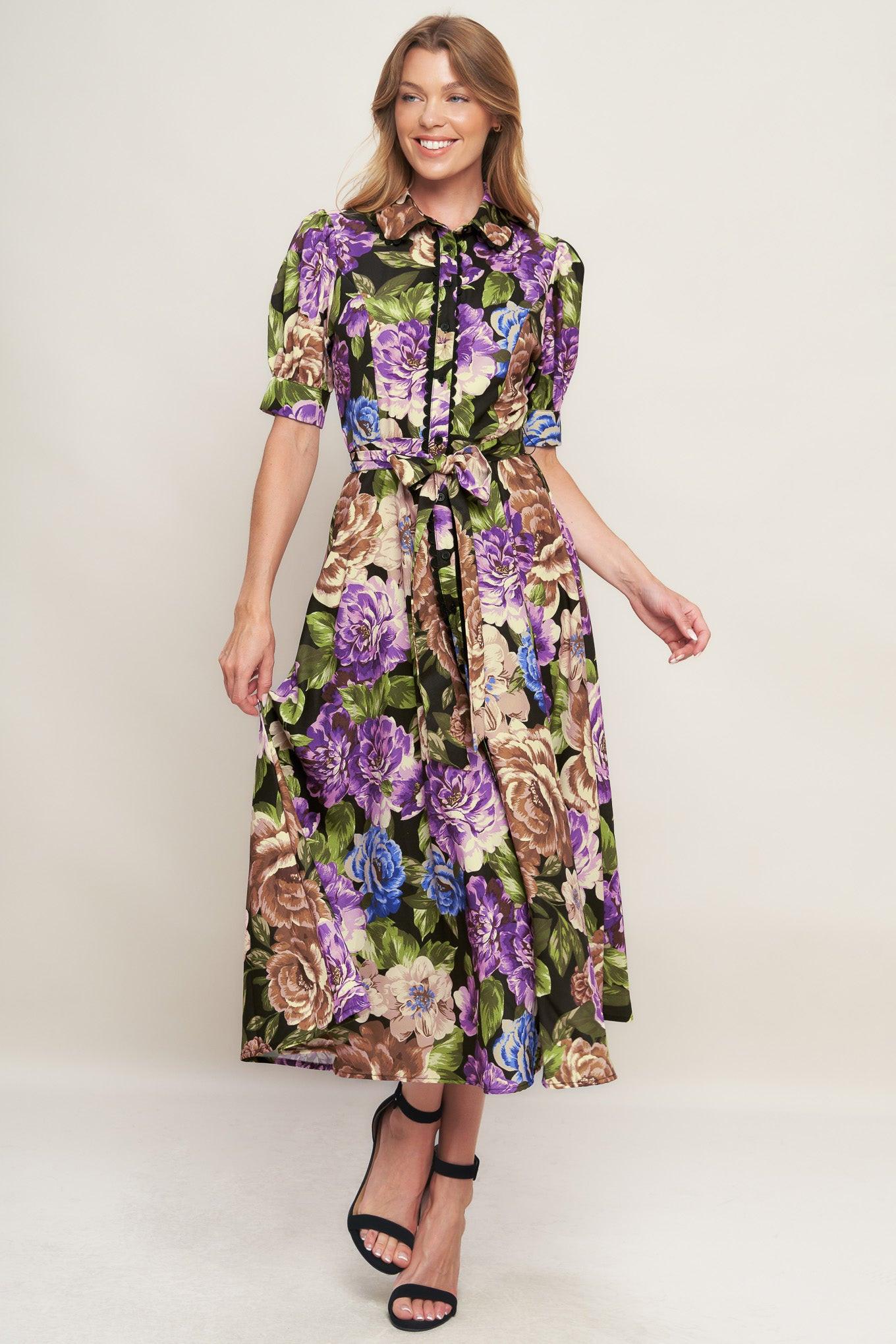 A printed woven midi dress featuring collar, short puff sleeve with cuff, button down closure and self sash tie