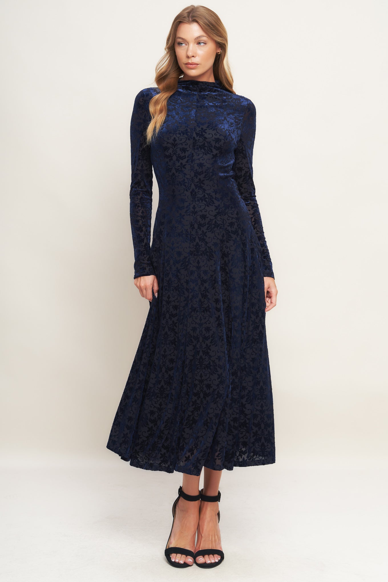 A knit burn out velvet midi dress featuring tubular neckline, long sleeve, circle skirt and back zipper closure