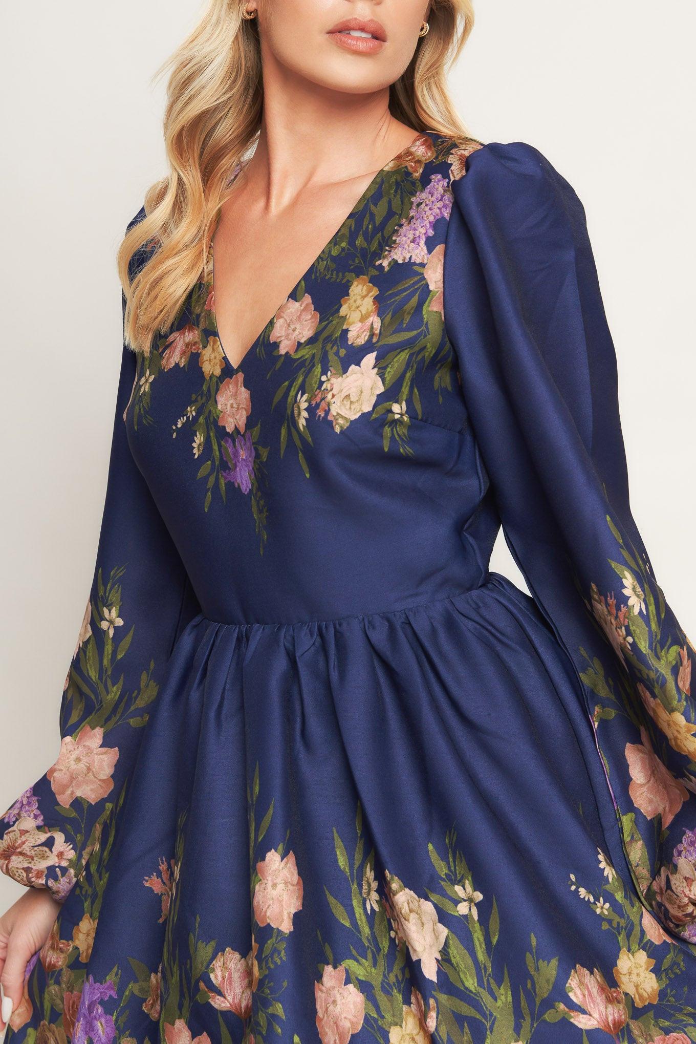A printed woven mini dress featuring V neckline, long sleeve, full skirt and back zipper closure