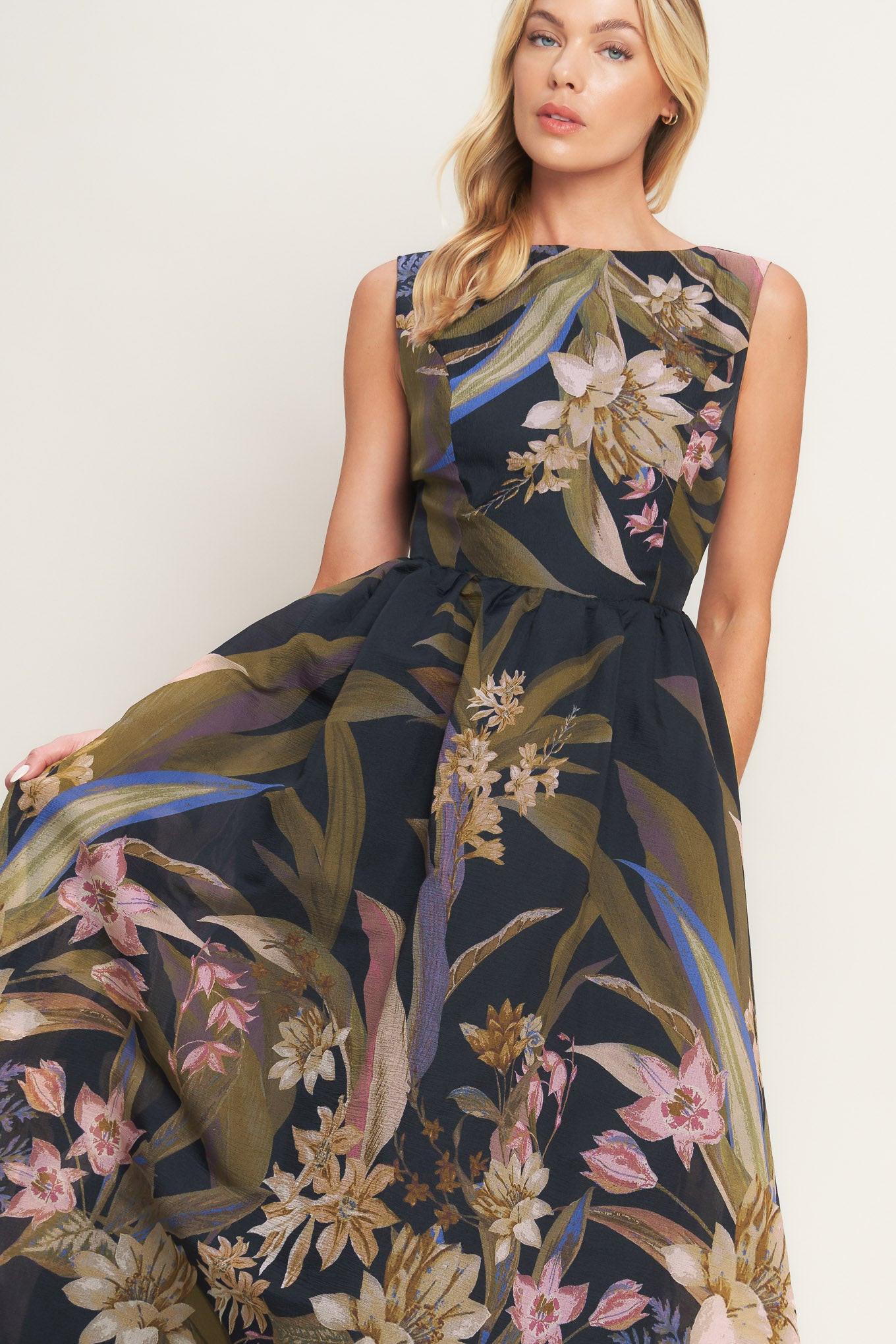 Woman wearing a black midi dress with floral and leaf print | Flying Tomato