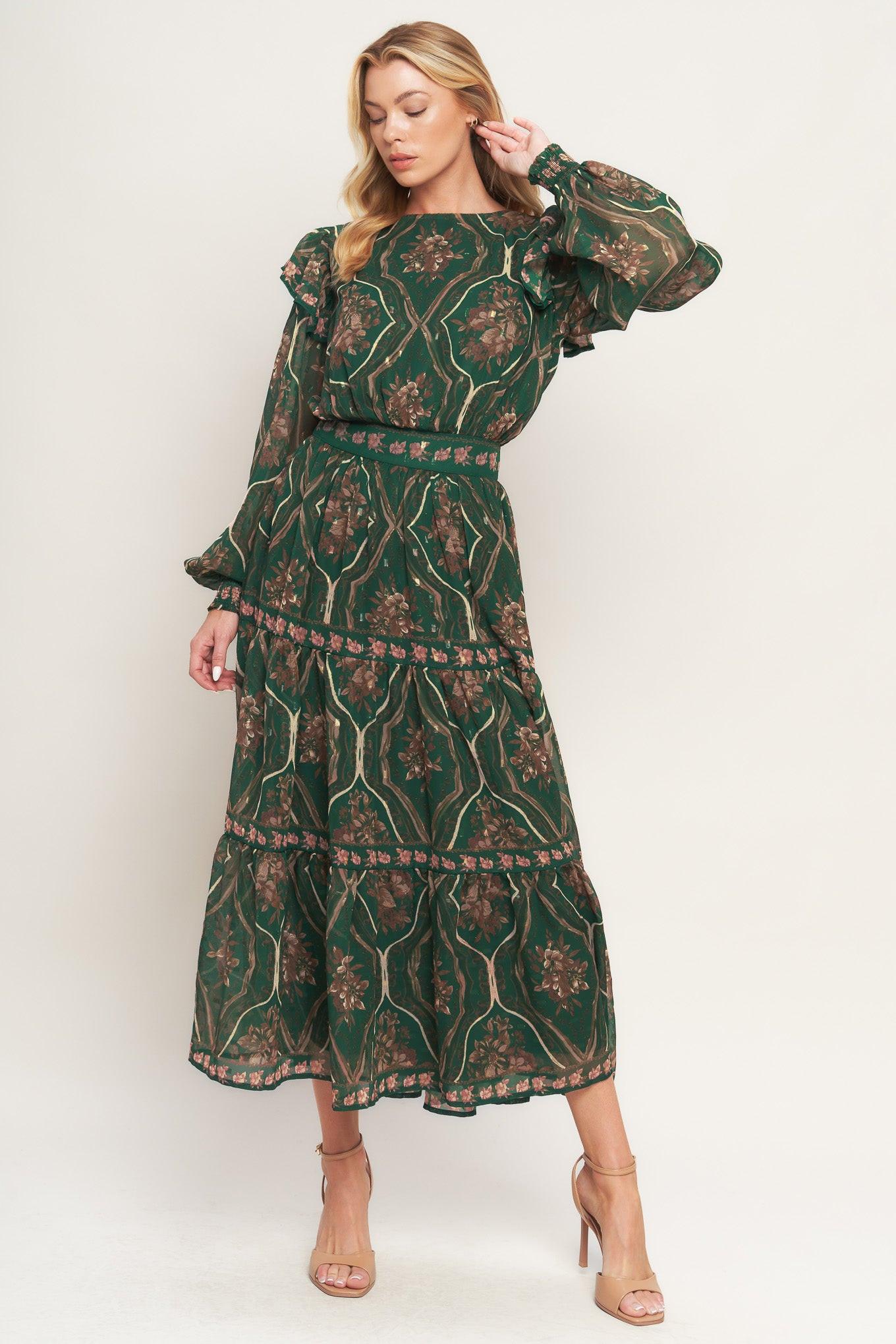 A printed woven midi dress featuring round neckline, long sleeve with ruffled shoulder, tiered skirt, smocked waist band and back neck button closure