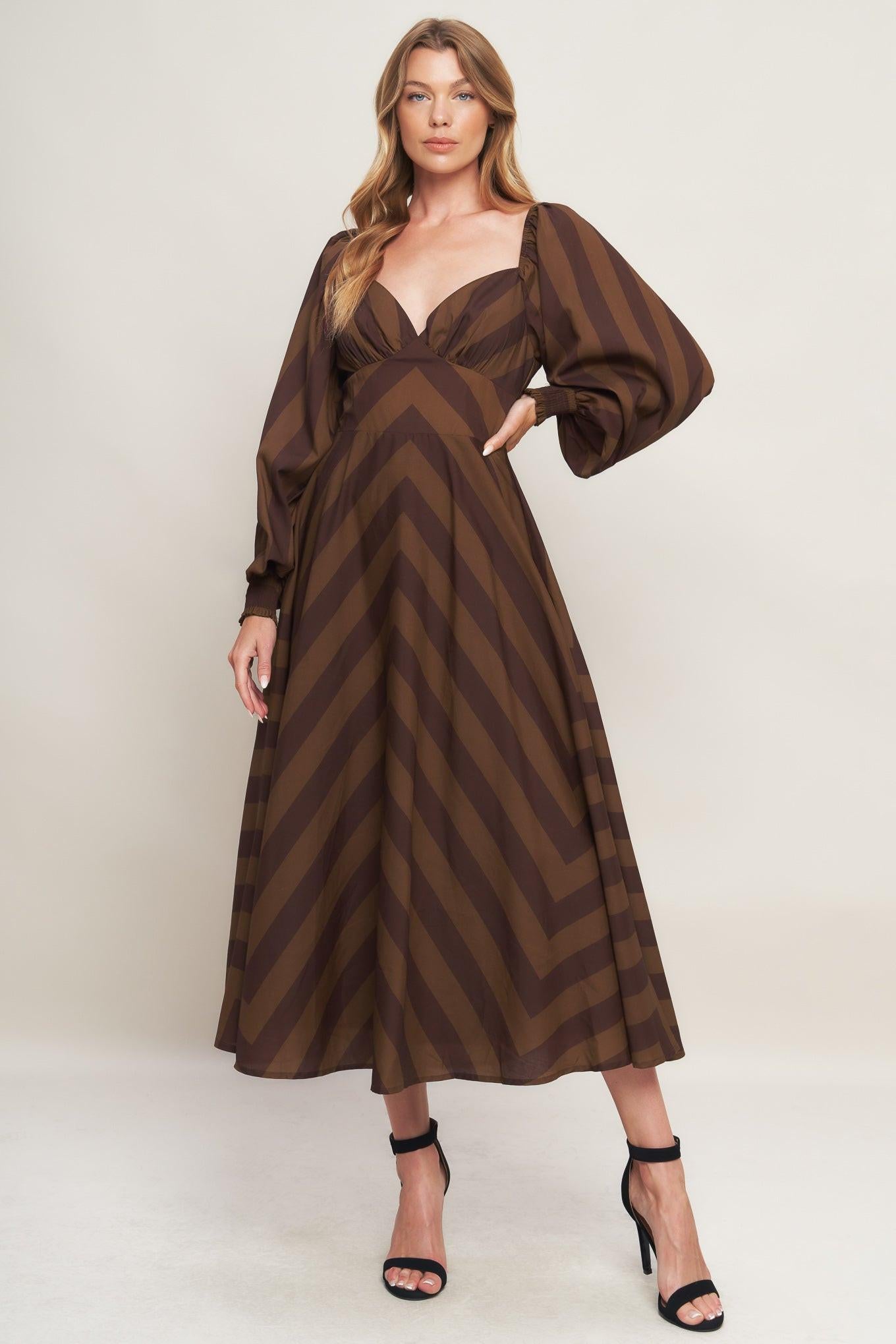 A printed woven midi dress featuring sweetheart neckline, long sleeve with smocked cuff, waist yoke, circle skirt and back zipper closure