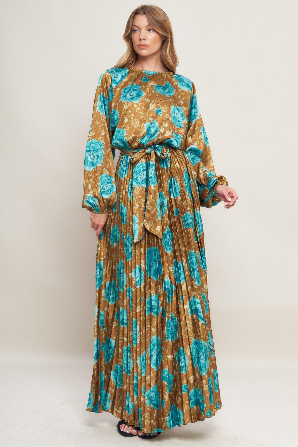 A printed woven satin maxi dress featuring round neckline, long sleeve, elasticized waist with pleated skirt and back button closure