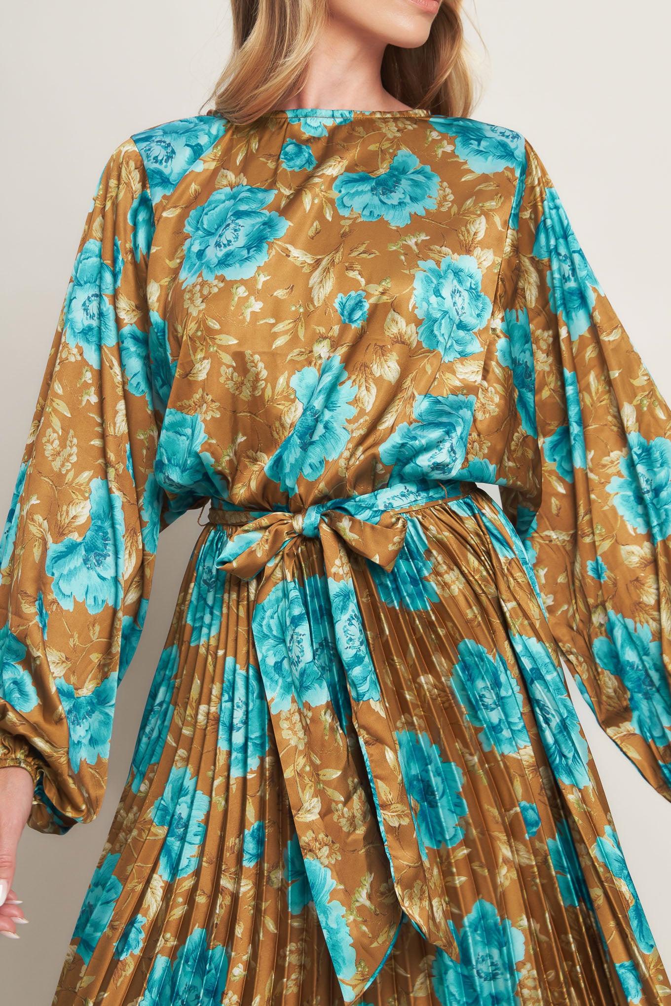 A printed woven satin maxi dress featuring round neckline, long sleeve, elasticized waist with pleated skirt and back button closure