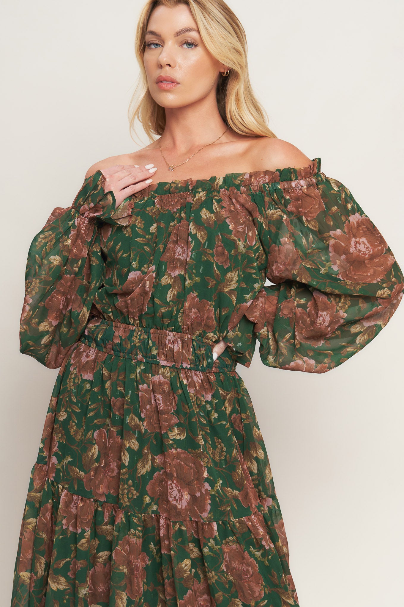 A printed woven midi dress featuring elasticized wide ruffled neckline, long sleeve with ruffled cuff, elasticized waist and tiered skirt