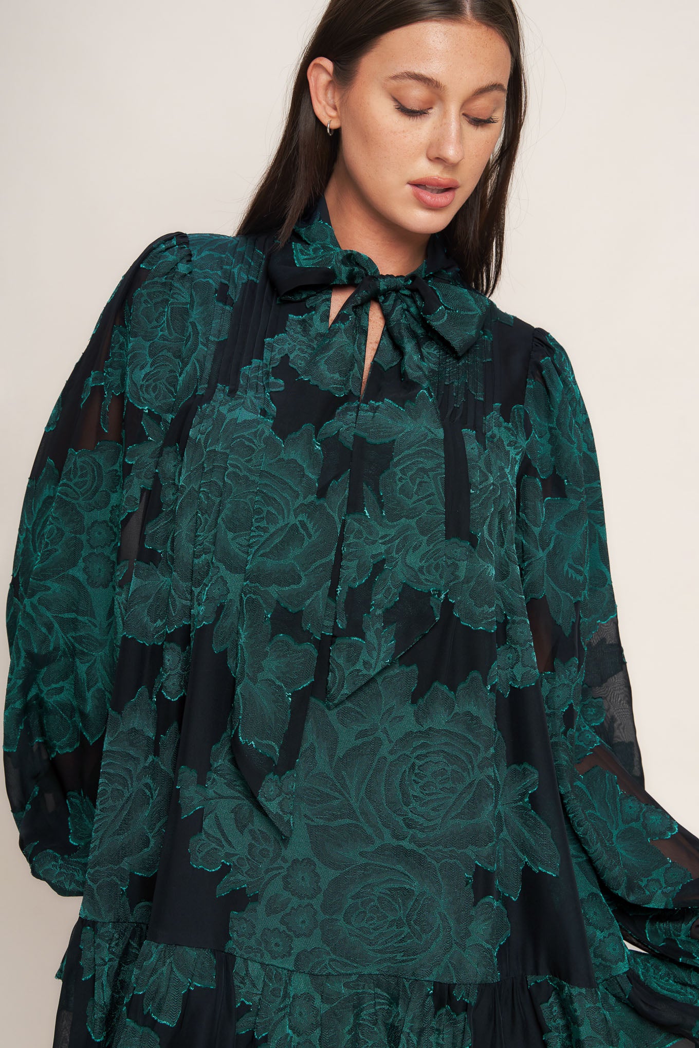 A burnout woven mini dress featuring front tie, long sleeve with ruffled cuff and ruffled hemline