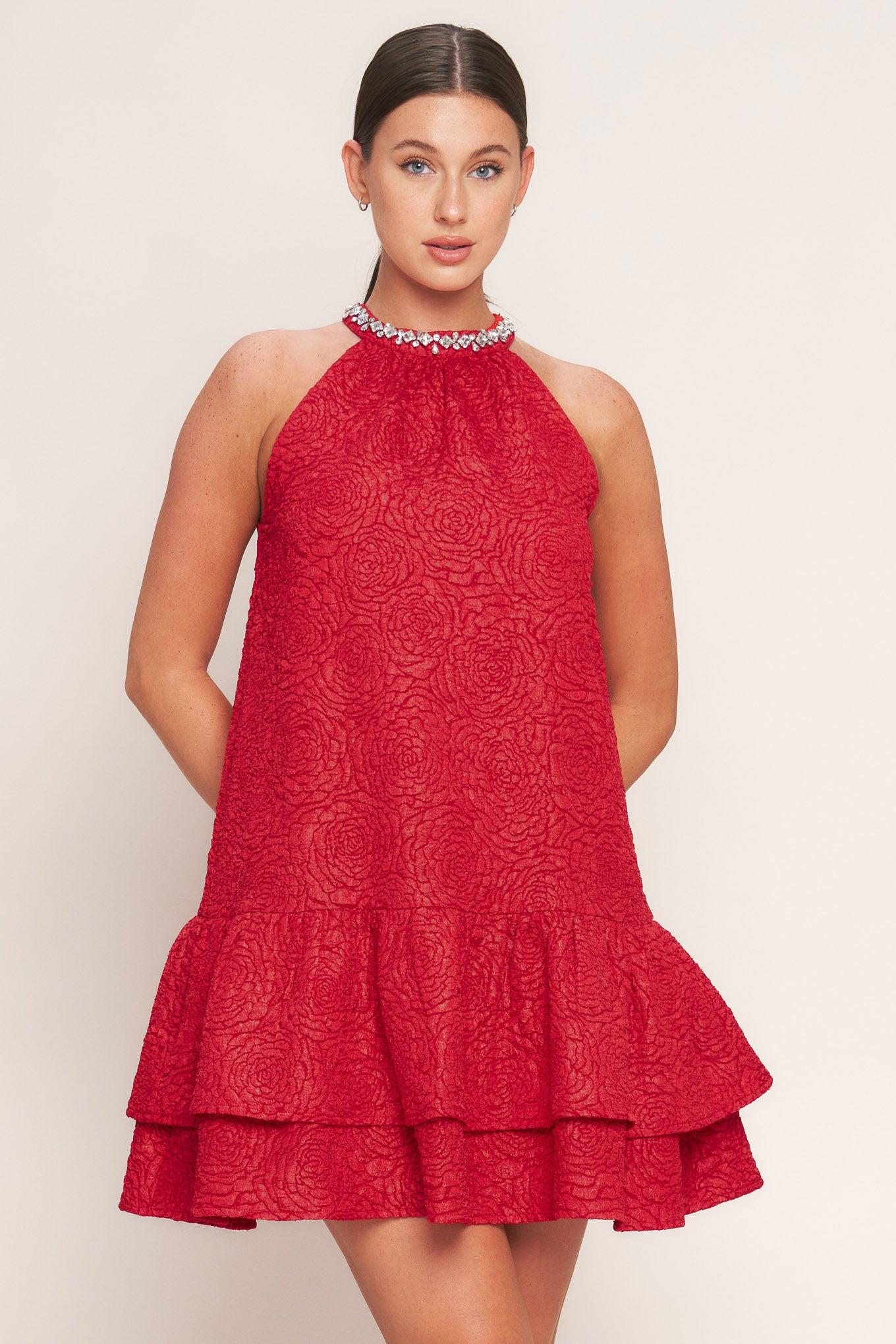 A textured woven mini dress featuring halter neckline with jewel embellishment, double ruffled hem and back neck button closure