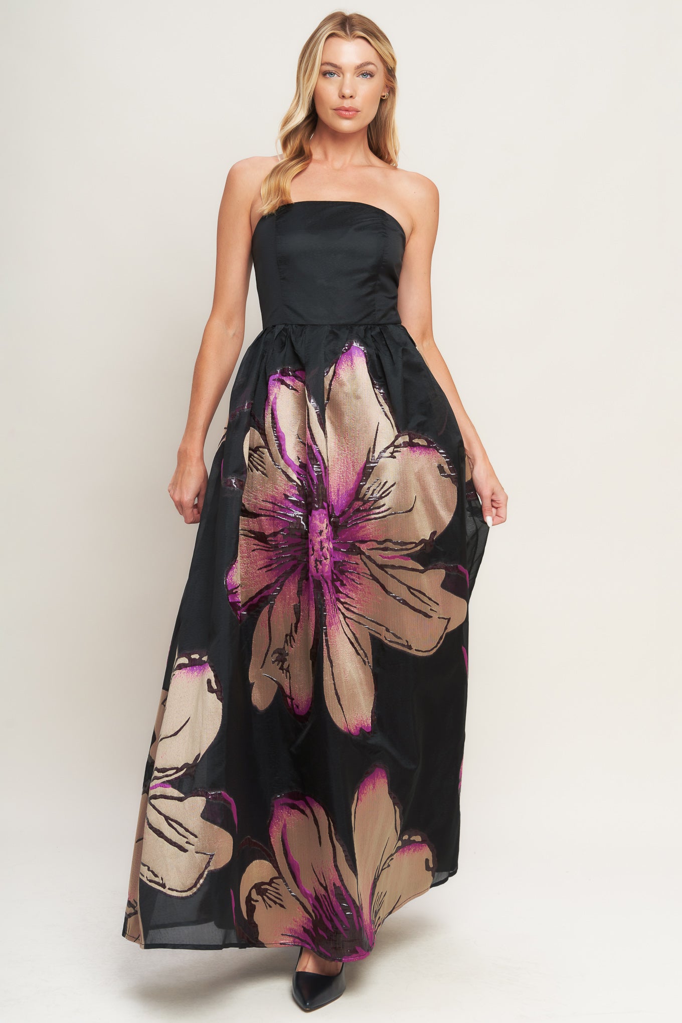A solid and printed woven maxi dress featuring solid tube top, printed full skirt and back zipper closure