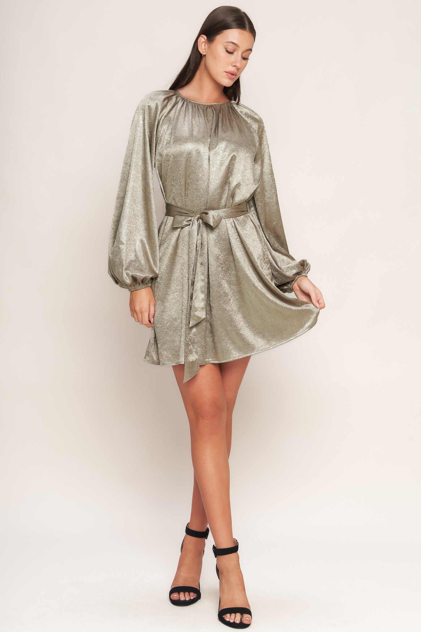 A foiled woven mini dress featuring round neckline, long sleeve, self sash tie and back neck button closure