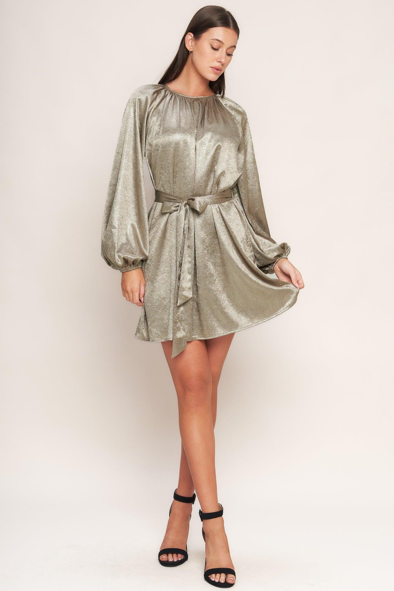 A foiled woven mini dress featuring round neckline, long sleeve, self sash tie and back neck button closure