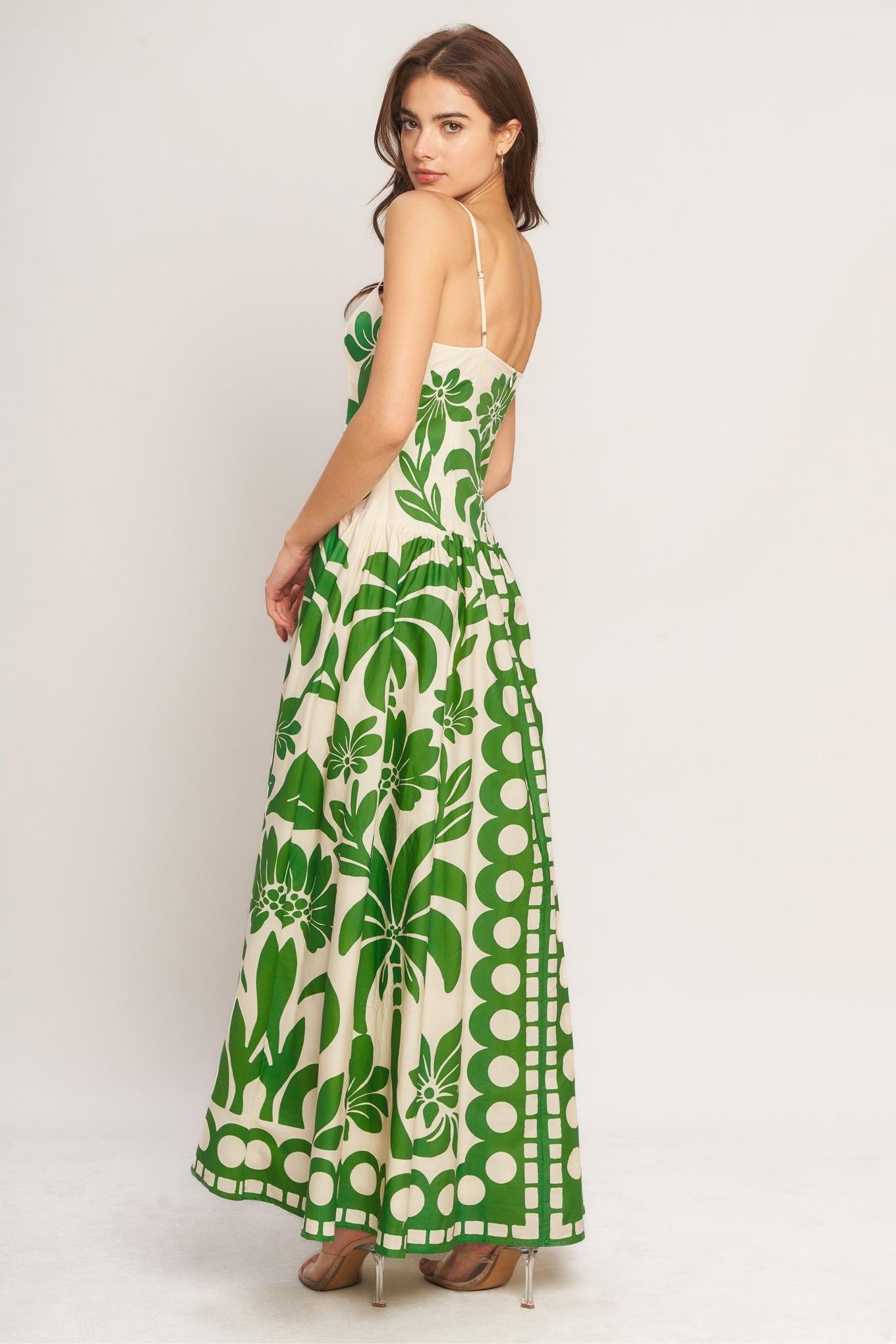 Woman wearing a green and white patterned dress on a plain background