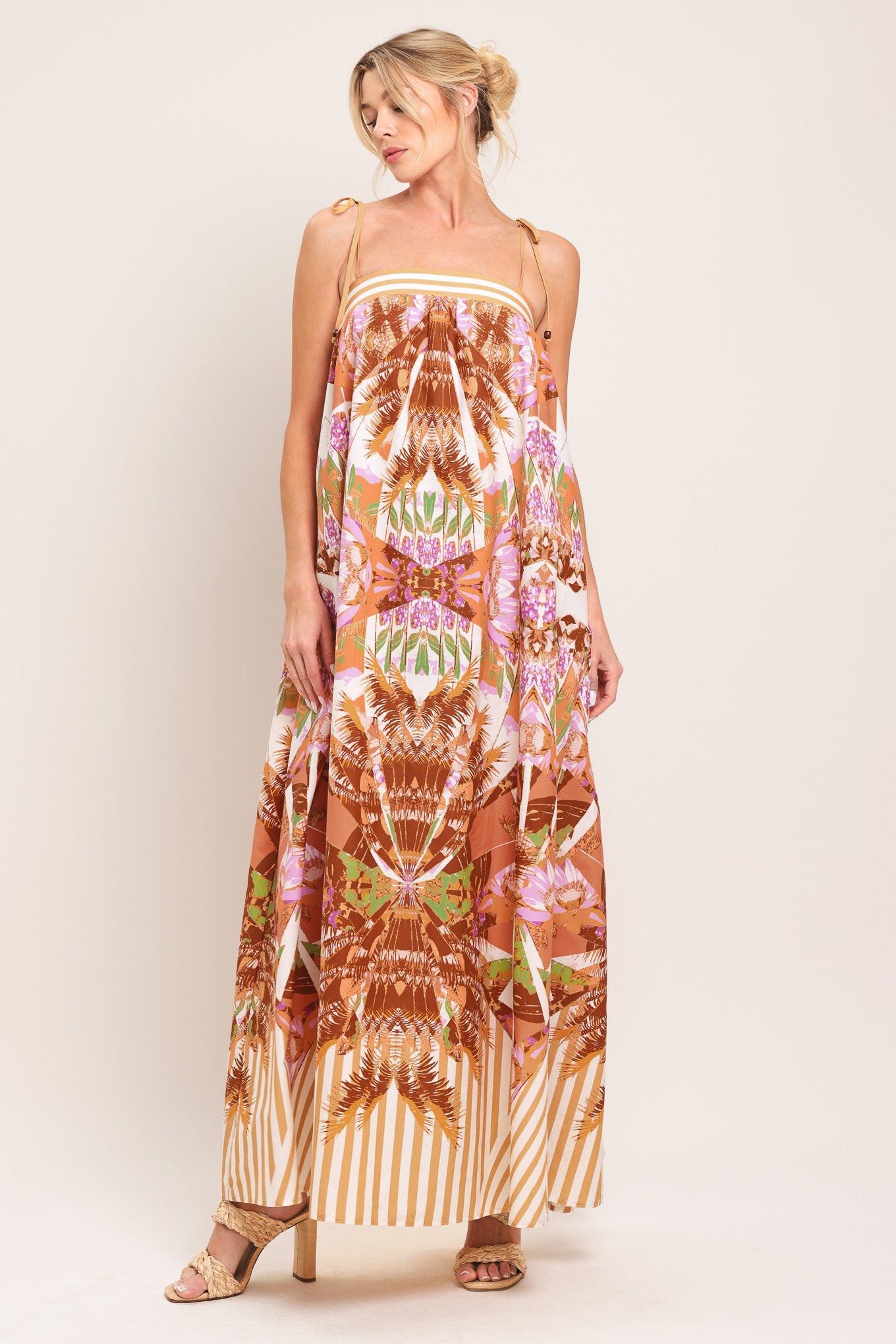 Woman wearing a maxi, patterned, multicolored orange and pink dress | Flying Tomato