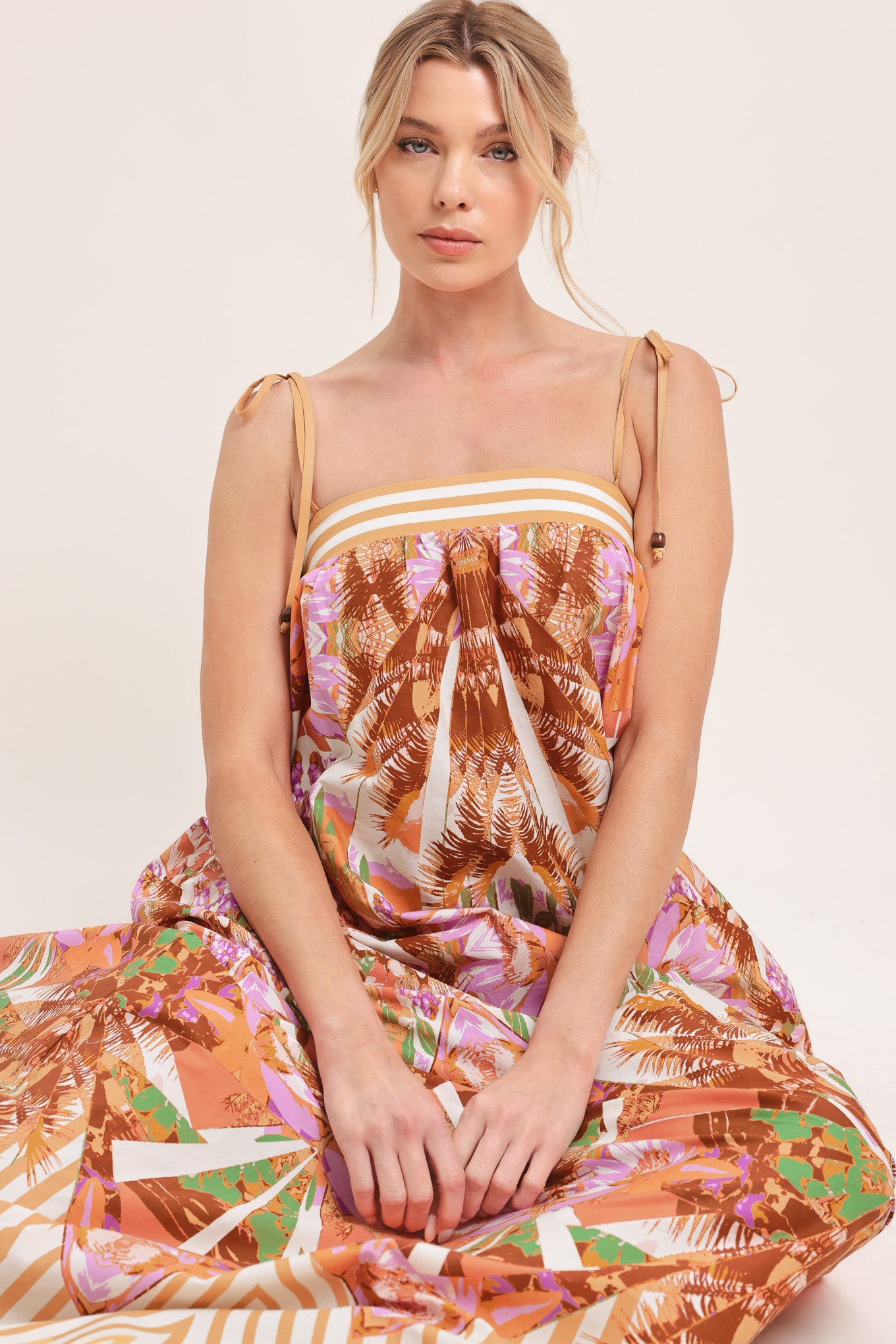 Woman wearing a maxi, patterned, multicolored orange and pink dress | Flying Tomato