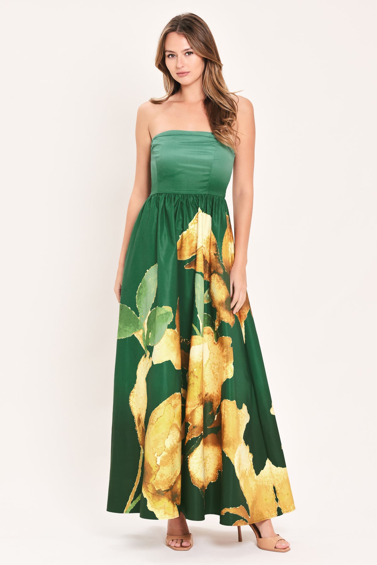 A woman modeling a strapless green maxi dress with a large yellow floral print on the skirt | Flying Tomato