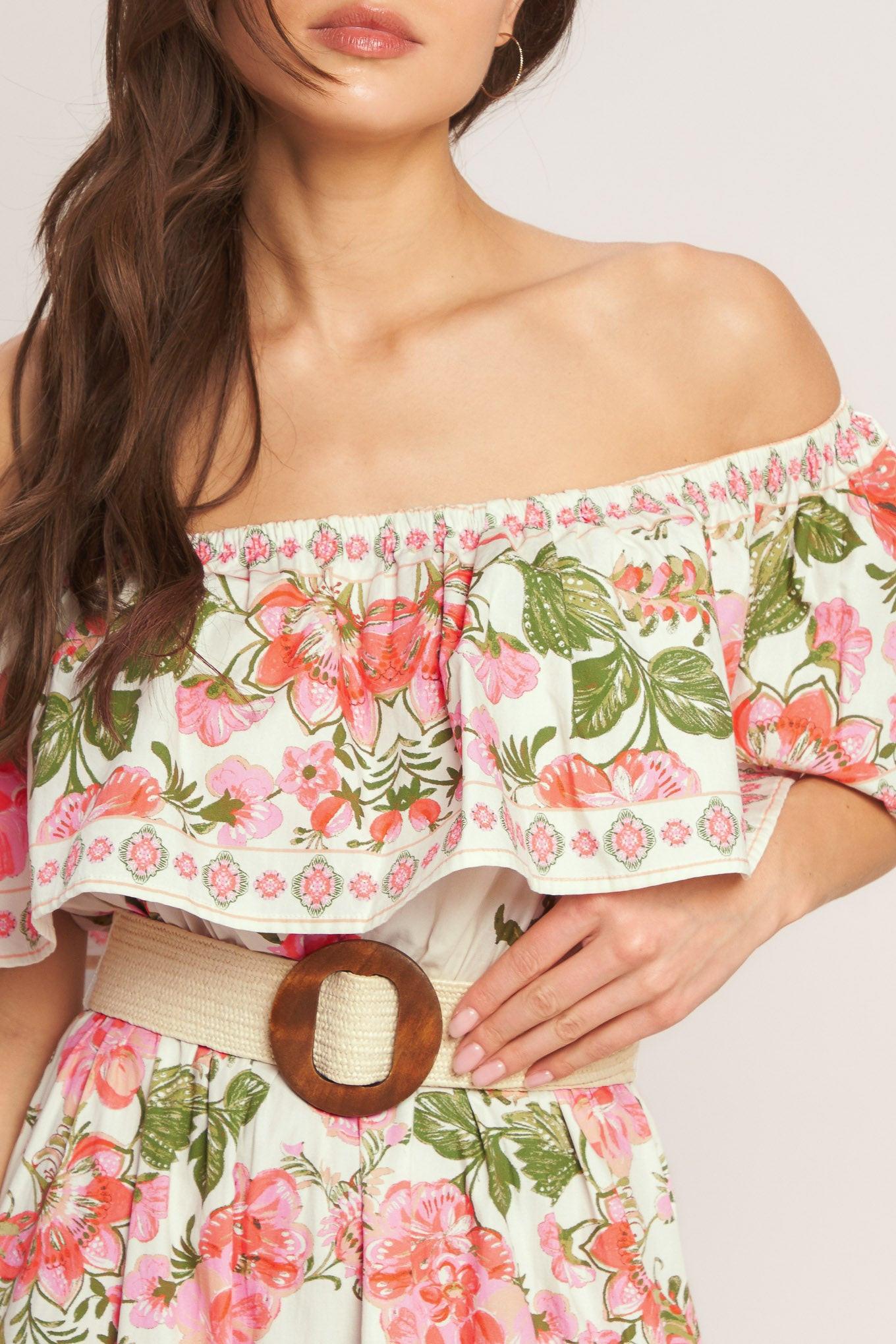 A printed maxi dress featuring off shoulder neckline with flounce, elasticized waist, contrasting belt and tiered skirt