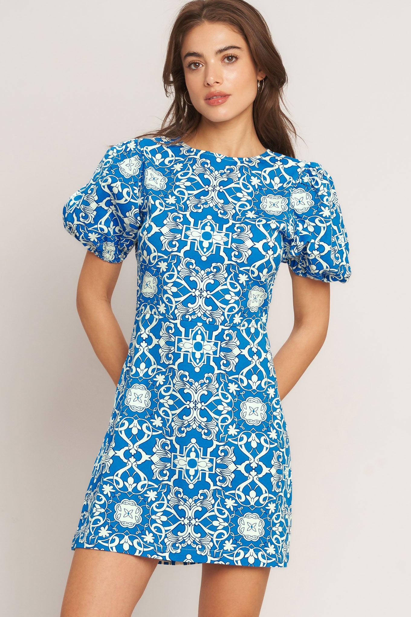 A printed woven mini dress featuring round neckline, short puff sleeve and back zipper closure