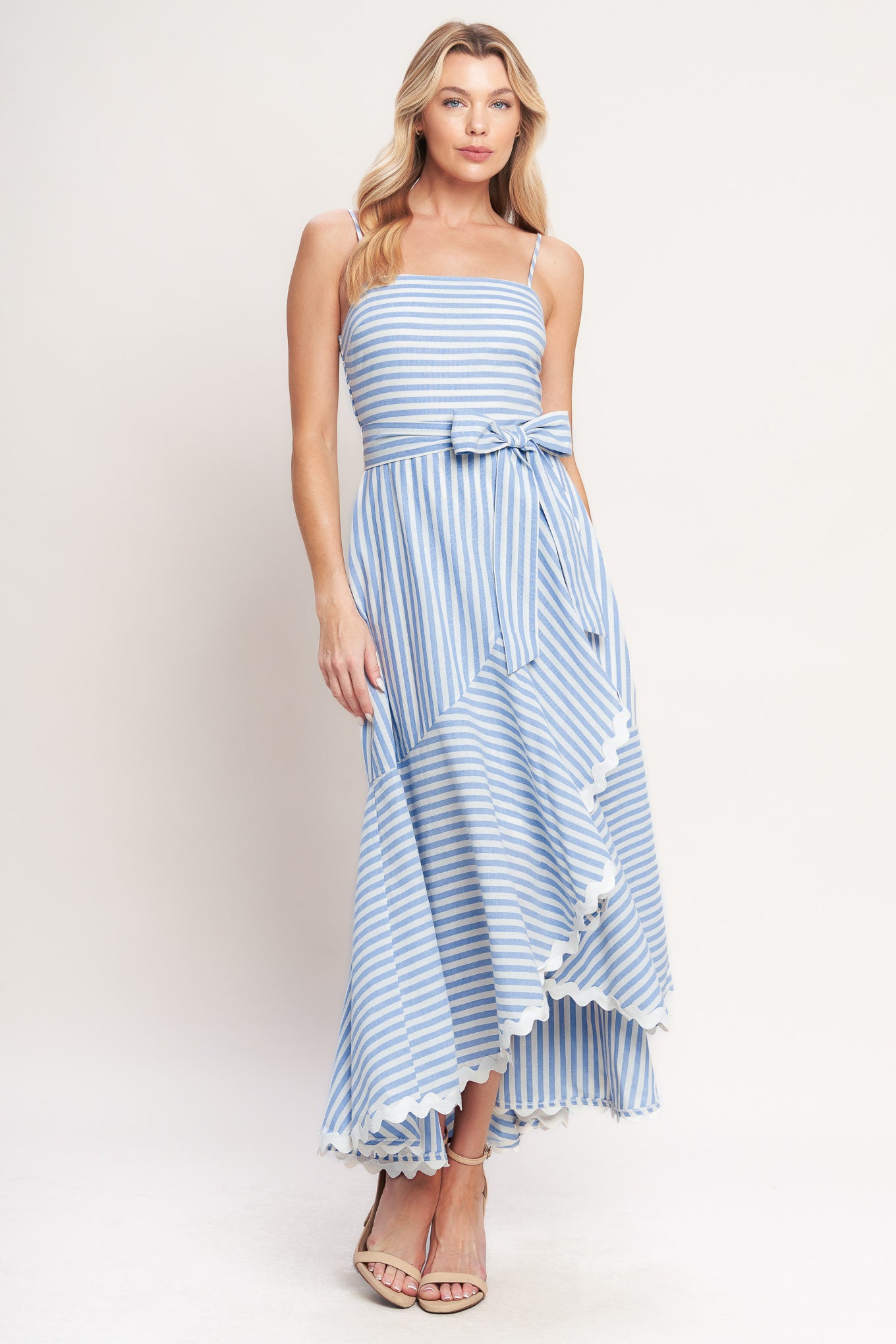 Blue-and-white striped midi dress with delicate straps, a waist bow tie, and a ruffled high-low hem
Details:
Self: 100% Cotton
Lining: 100% Polyester Exclusive of Decoration
Size & Fit
- Model is 5`8" And Wearing Size Small
- Measurements Taken From Size Small
- Approx. Length: 53"