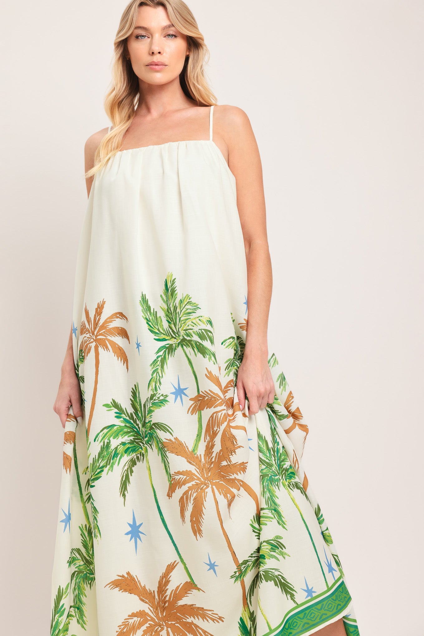 Woman wearing a white dress with green and rustic orange palm tree pattern | Flying Tomato