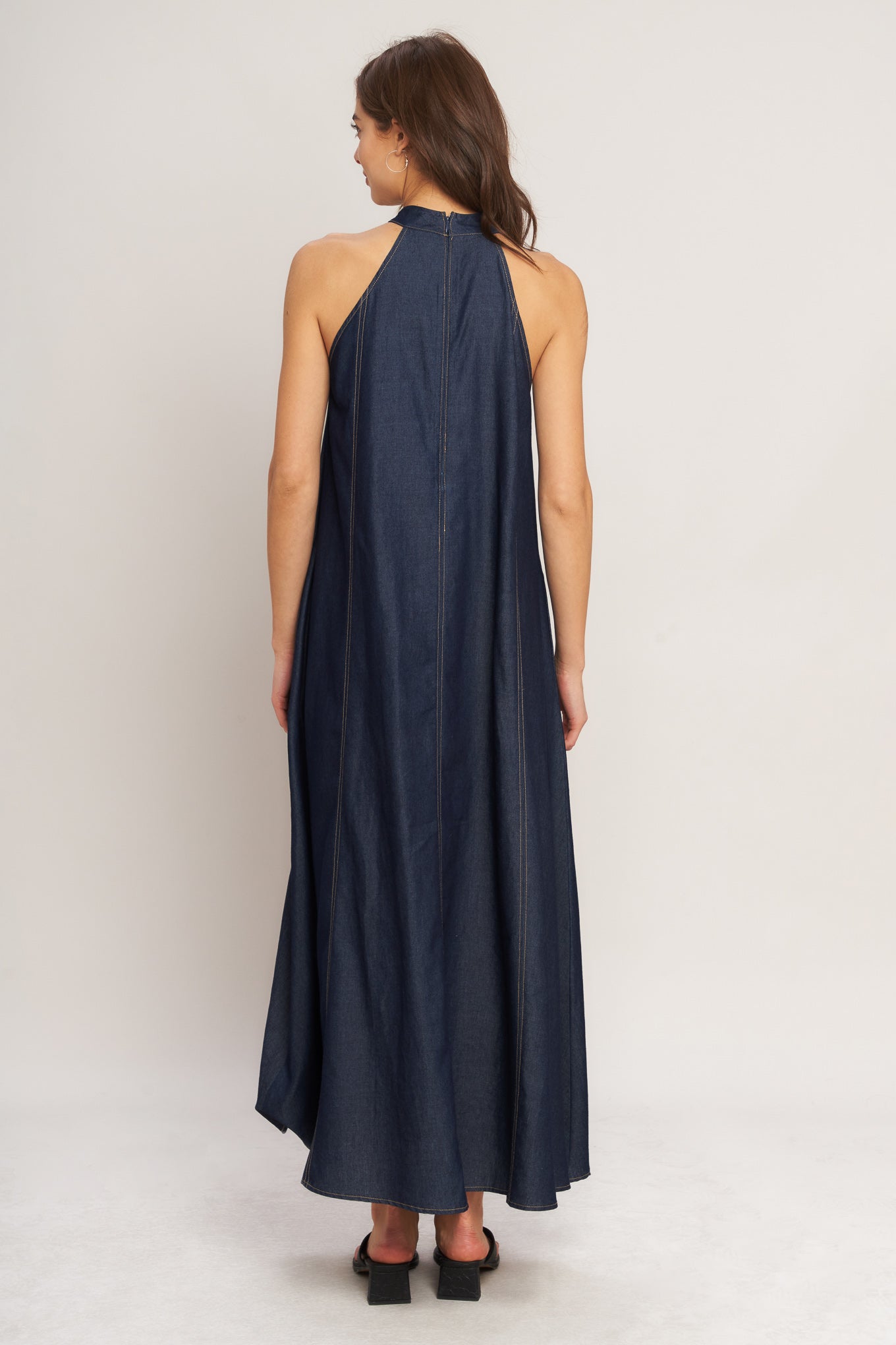 A solid woven midi halter dress with back neck button closure and side pockets