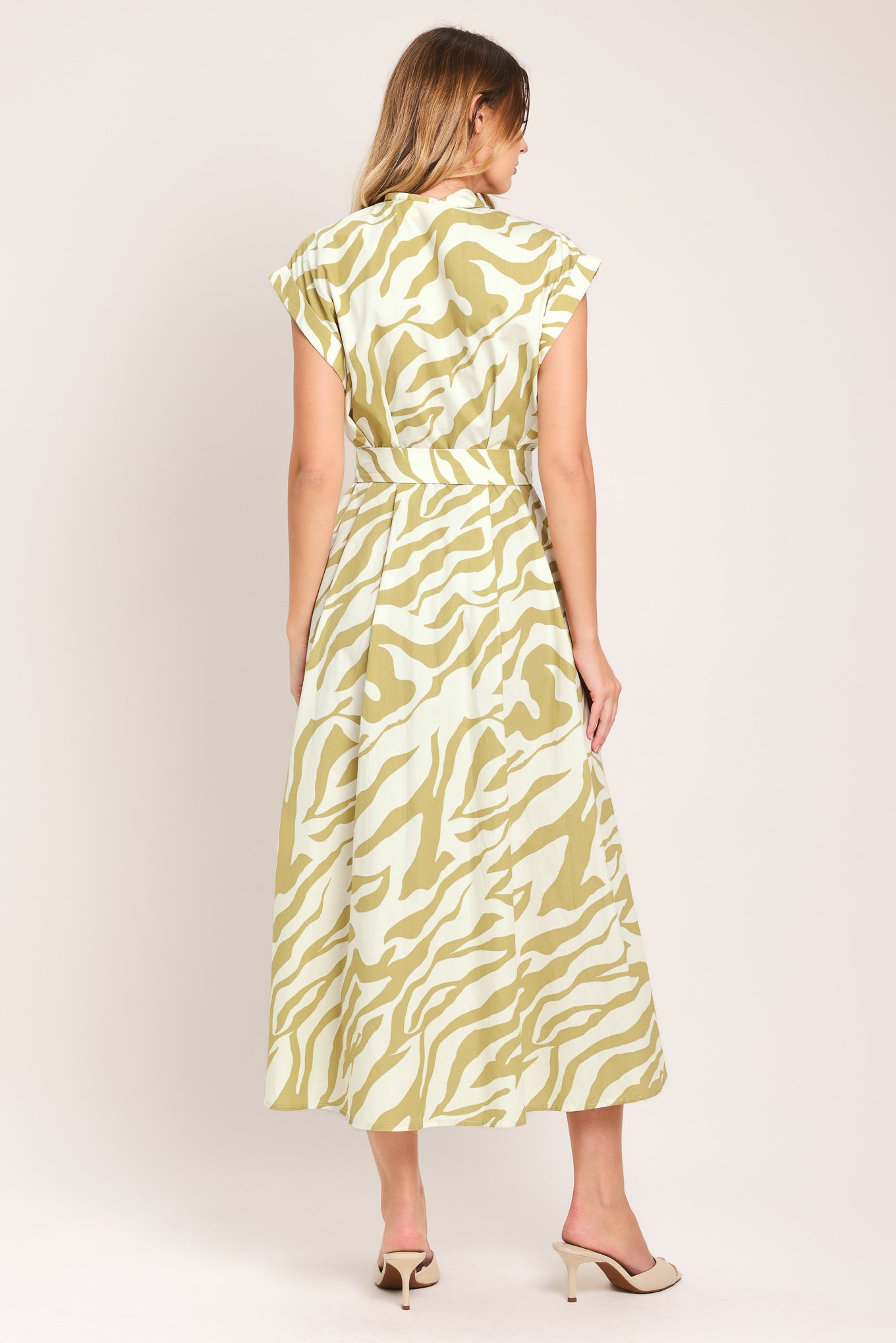 Woman wearing an ivory with taupe zebra printed midi shirt dress featuring cuffed short sleeve, front button down, self belt and side pockets | Flying Tomato