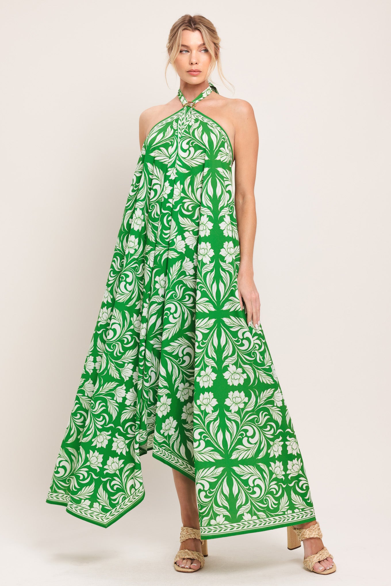 Woman wearing a green and white patterned halter neck midi dress with hardware detail, bare back, and tie closure | Flying Tomato