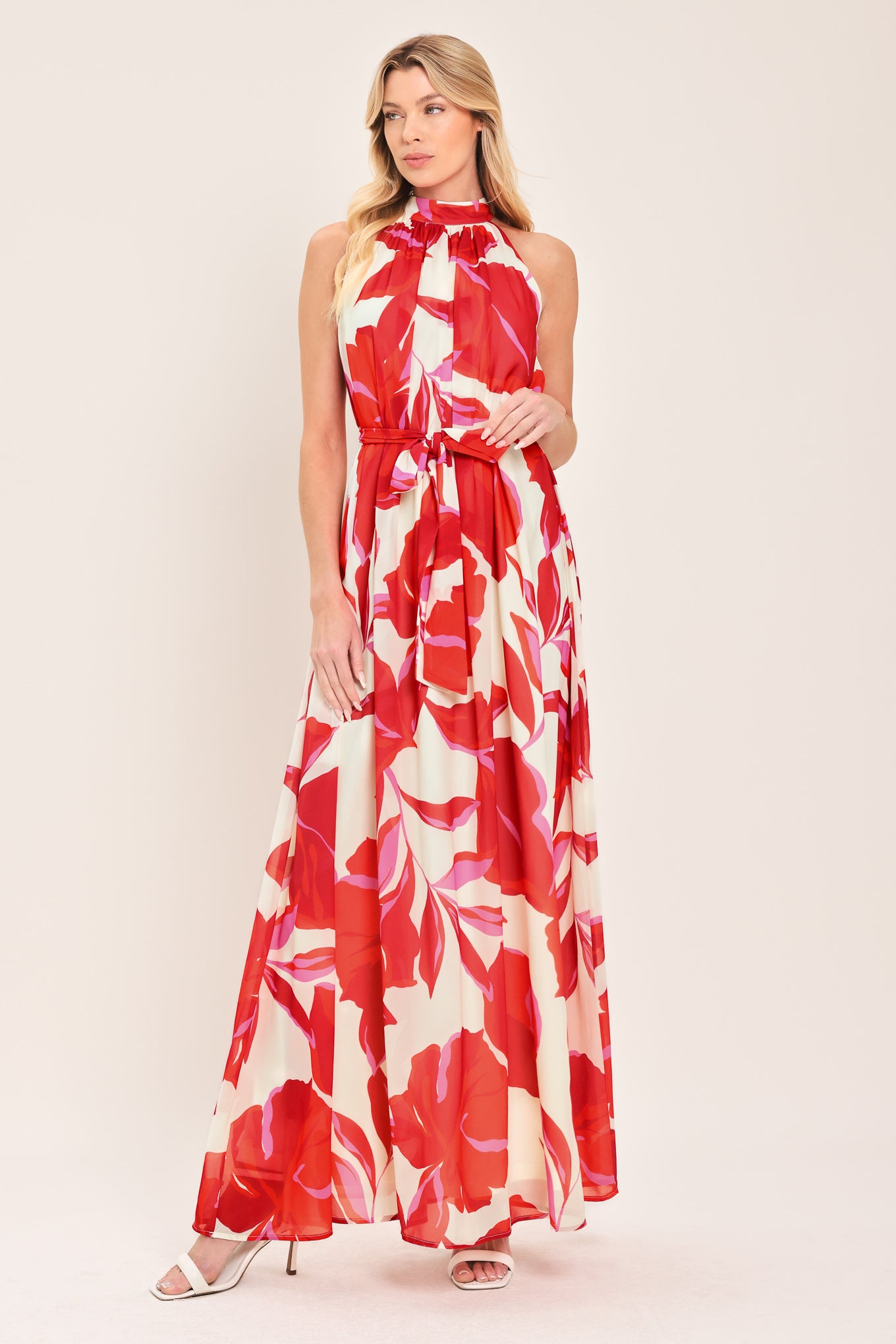 Woman wearing a red floral maxi dress with halter neckline, self sash tie and back button closure | Flying Tomato