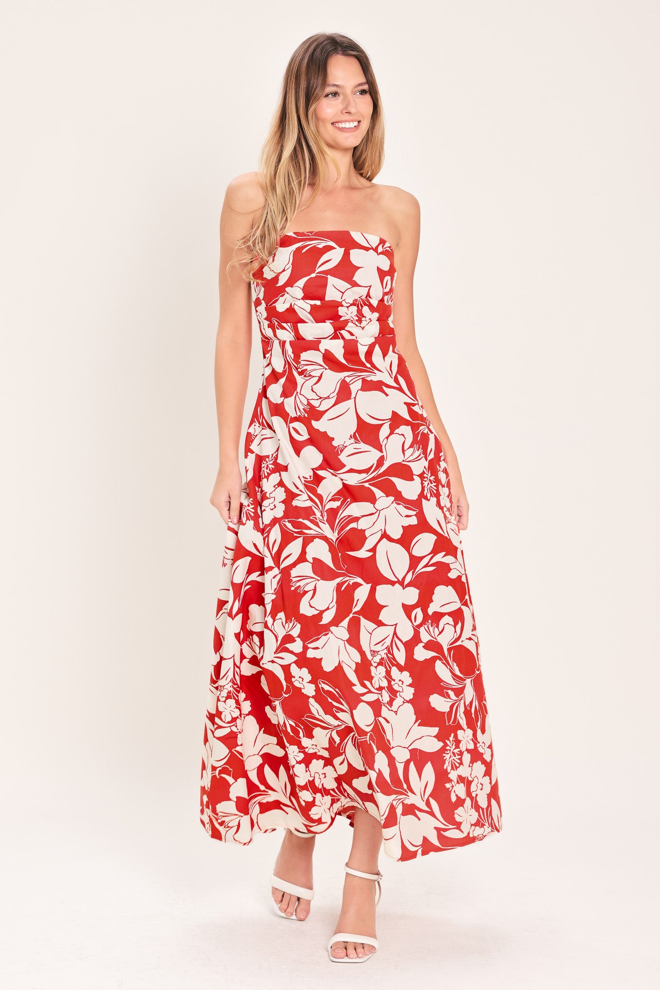 Woman wearing a red floral strapless midi dress featuring a circle skirt and back zipper closure | Flying Tomato