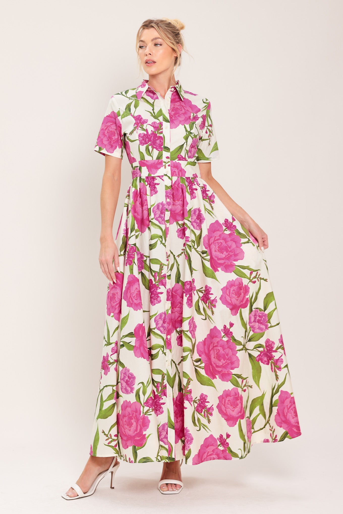 Woman wearing a short sleeve white shirt maxi dress wit pink floral print featuring front button down and full skirt | Flying Tomato