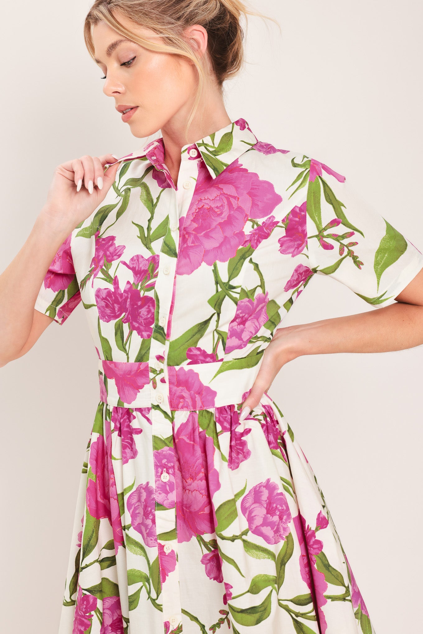 Woman wearing a short sleeve white shirt maxi dress wit pink floral print featuring front button down and full skirt | Flying Tomato