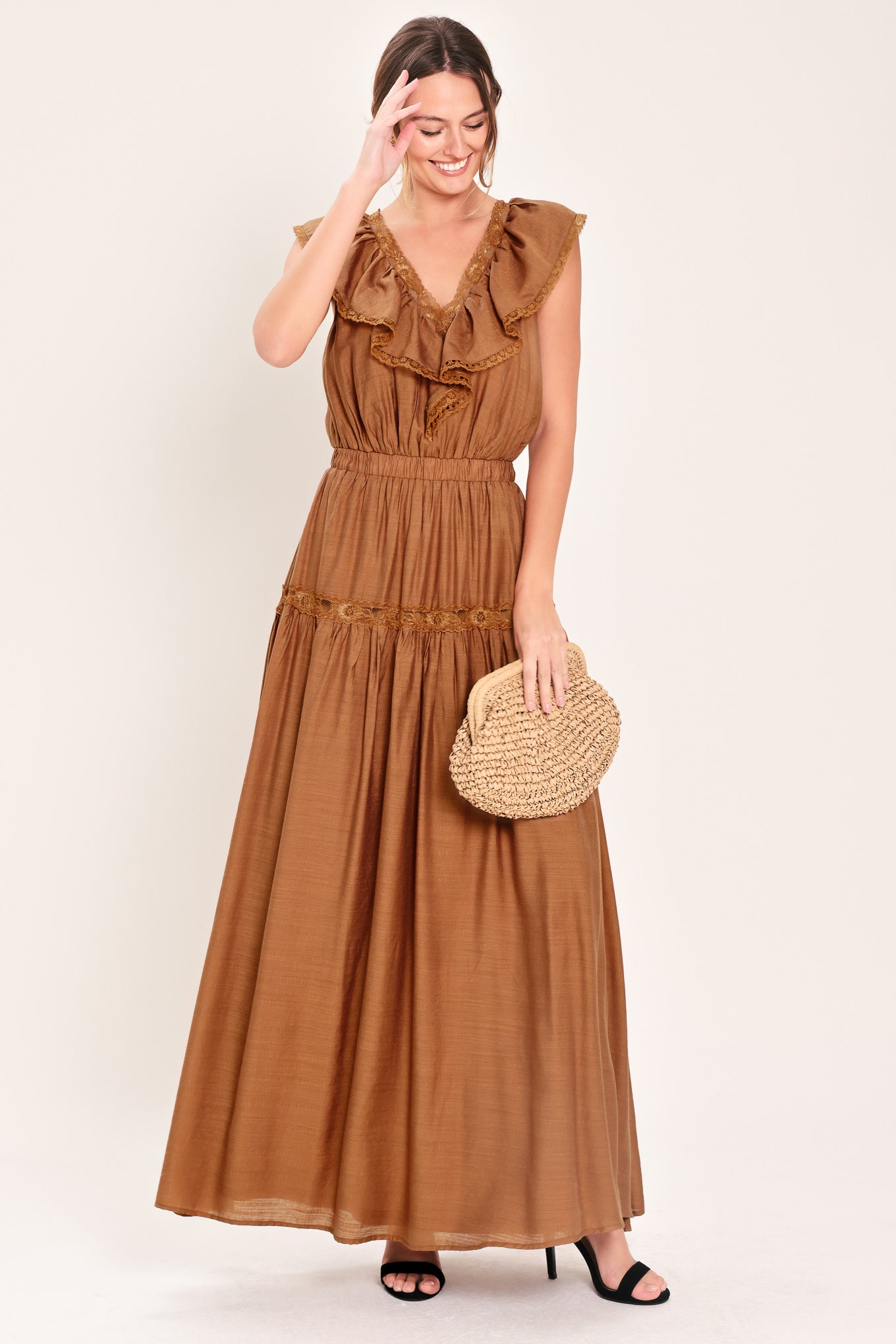 Woman wearing a brown maxi dress featuring V neckline with ruffle and lace edge, elastic waist and back tie | Flying Tomato