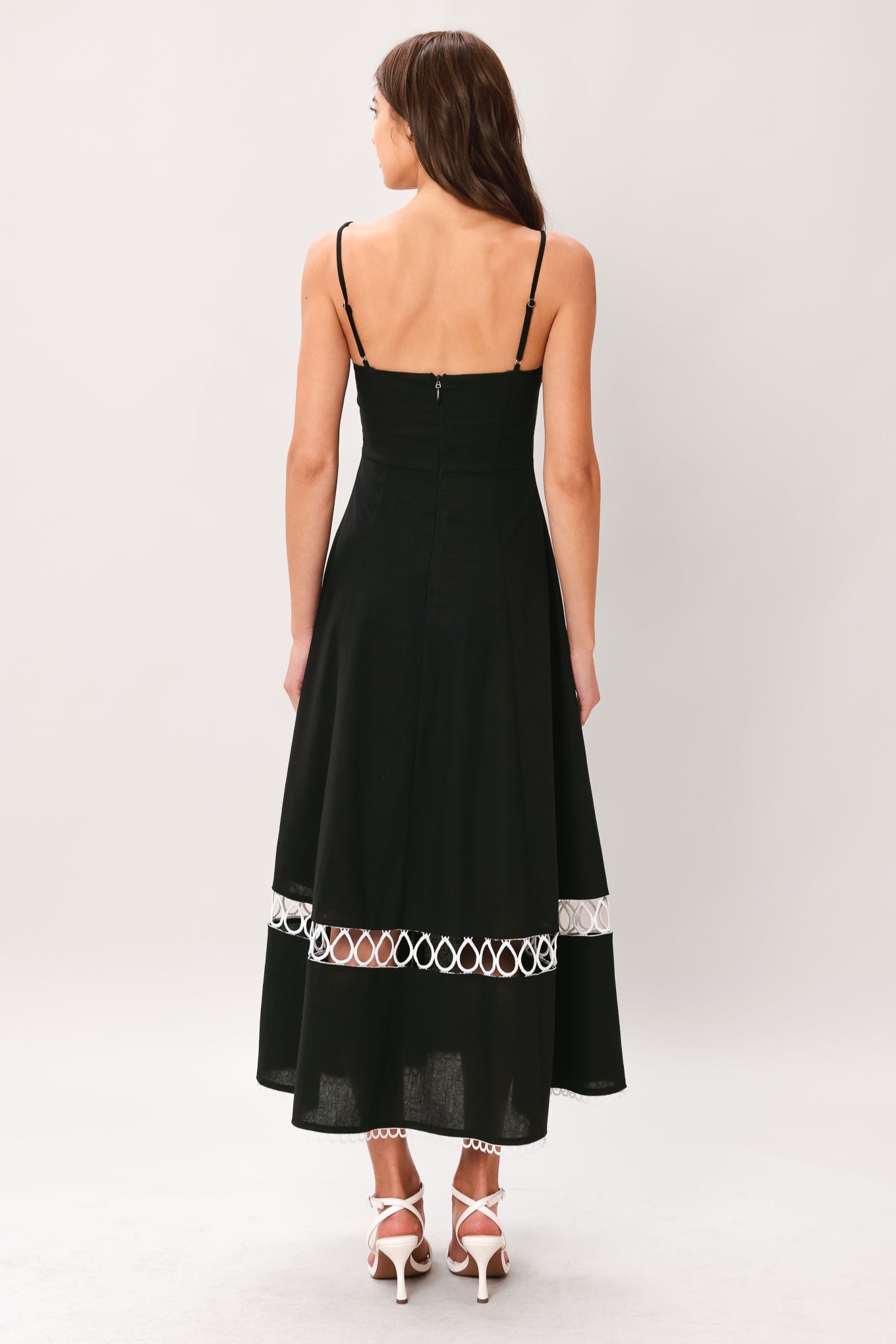 Woman wearing a black midi dress featuring straight neckline with lace edge trim, straps, circle skirt with lace inset bottom, lace edge trim and back zipper closure | Flying Tomato